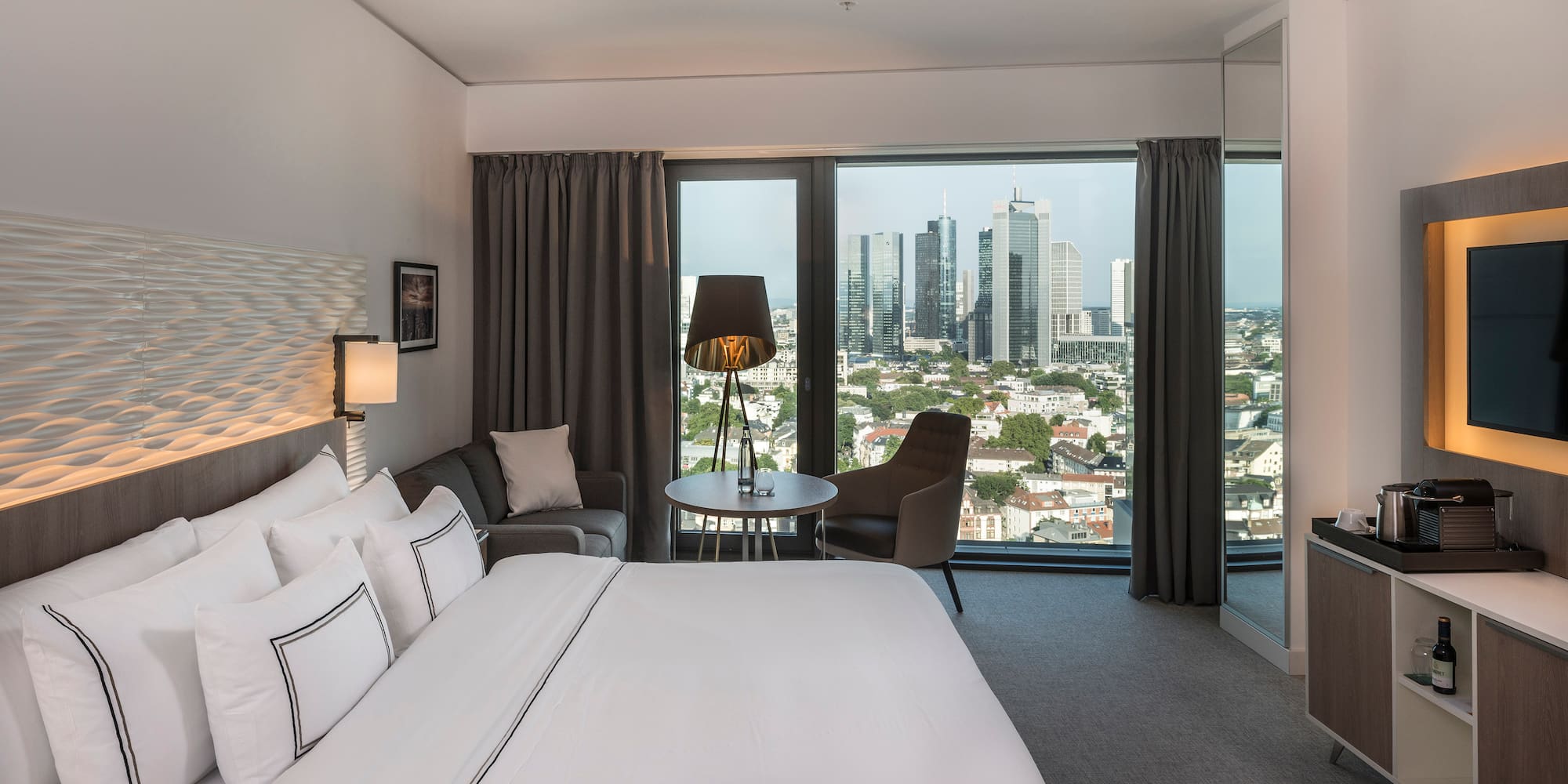 a hotel room with a large window and a large bed