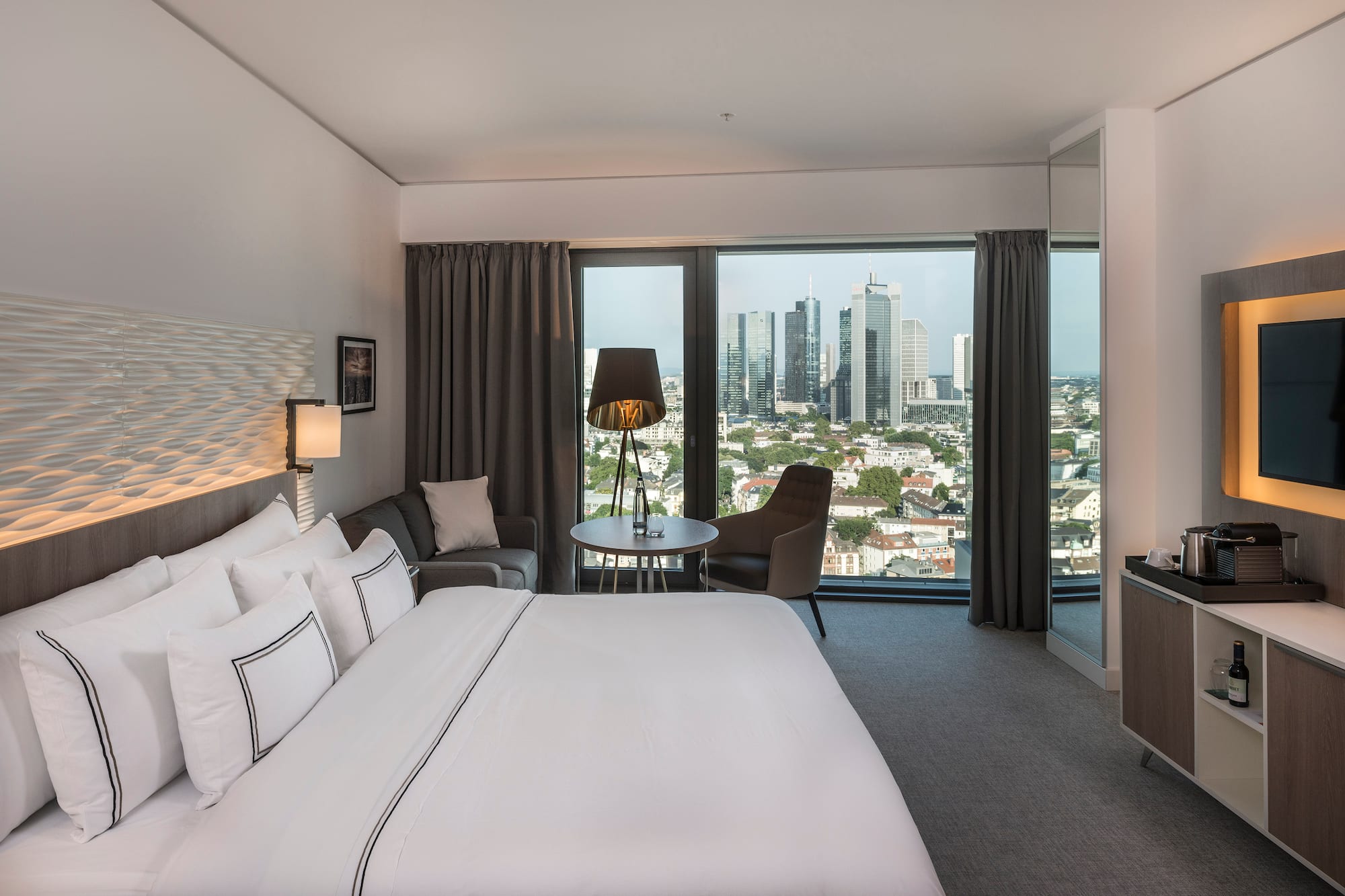 a hotel room with a large window and a large bed