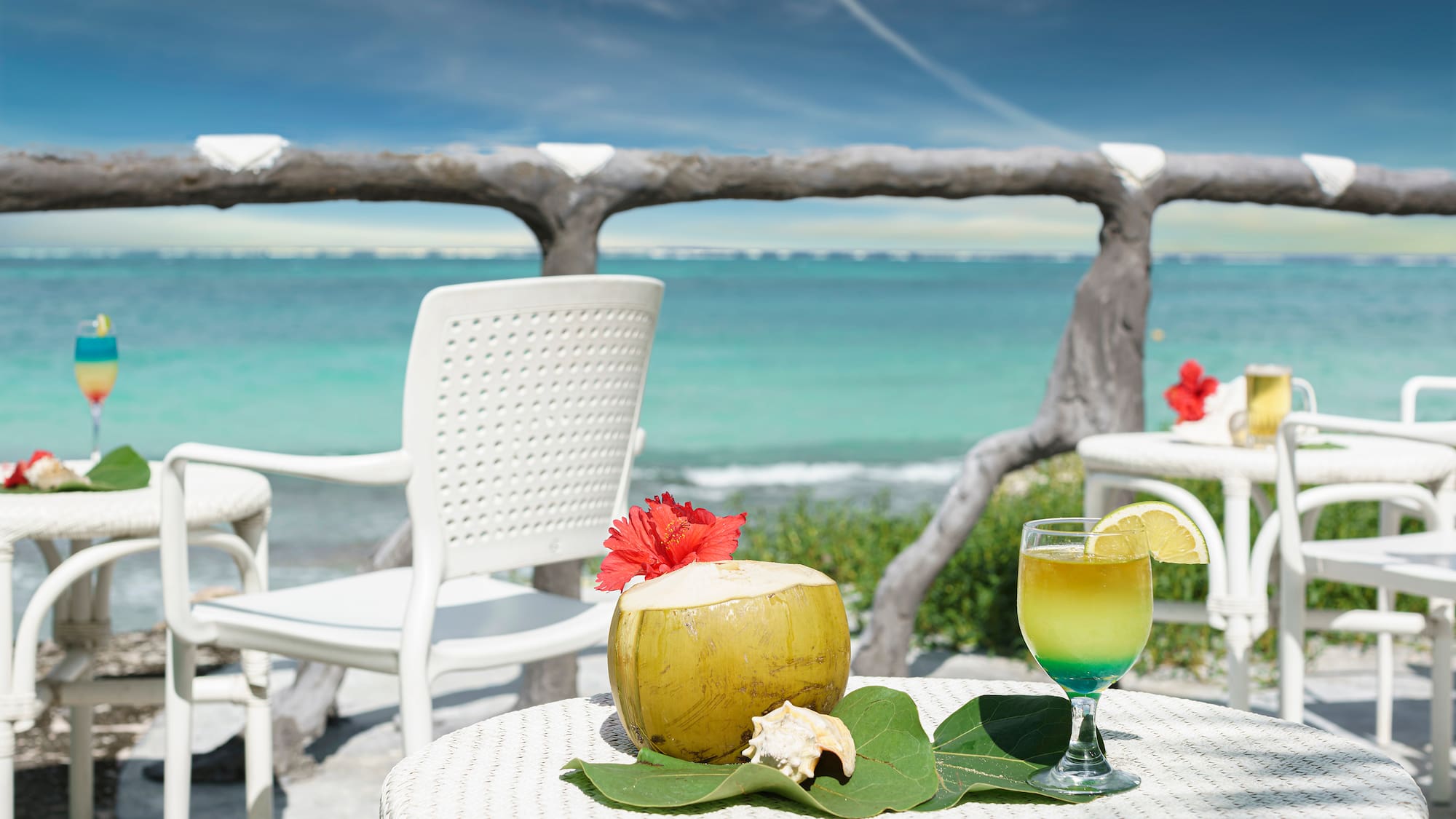 a table with a drink on it and a coconut on it