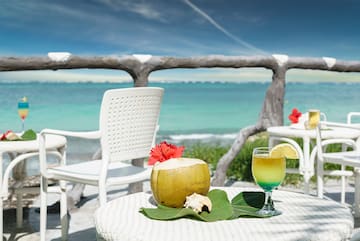 a table with a drink on it and a coconut on it