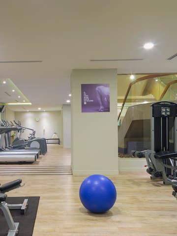 a room with exercise equipment and a blue ball