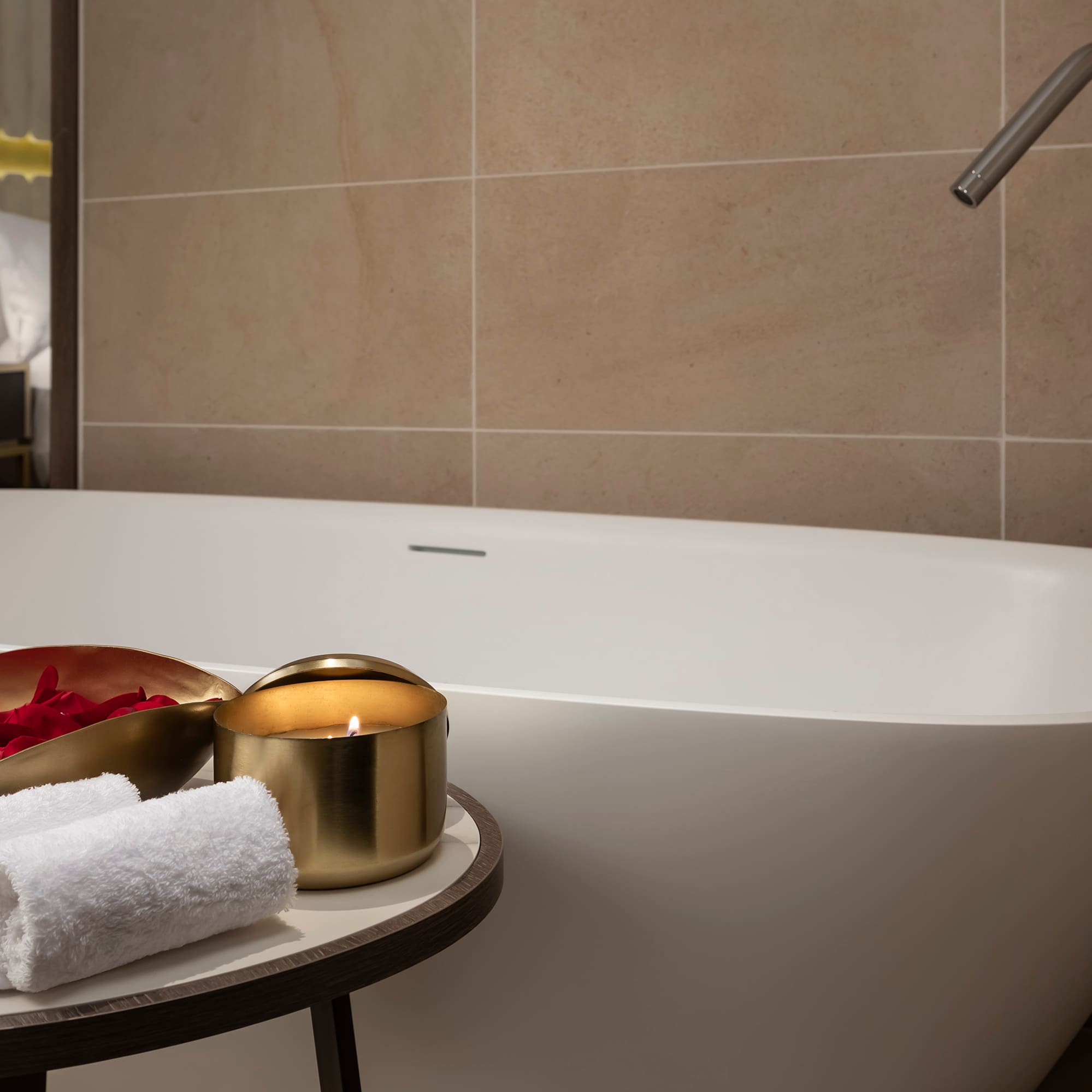 a bathtub with a candle and towels