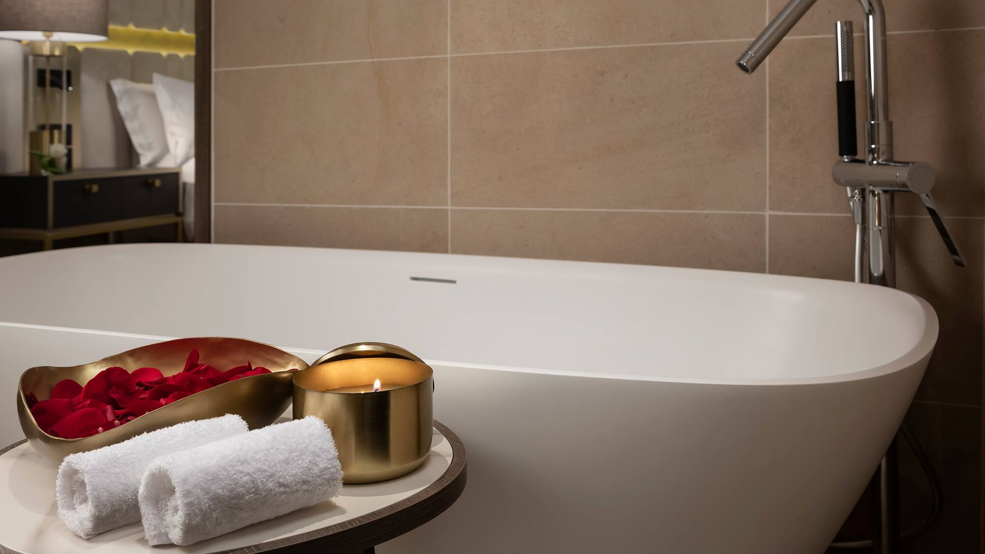 a bathtub with a candle and towels