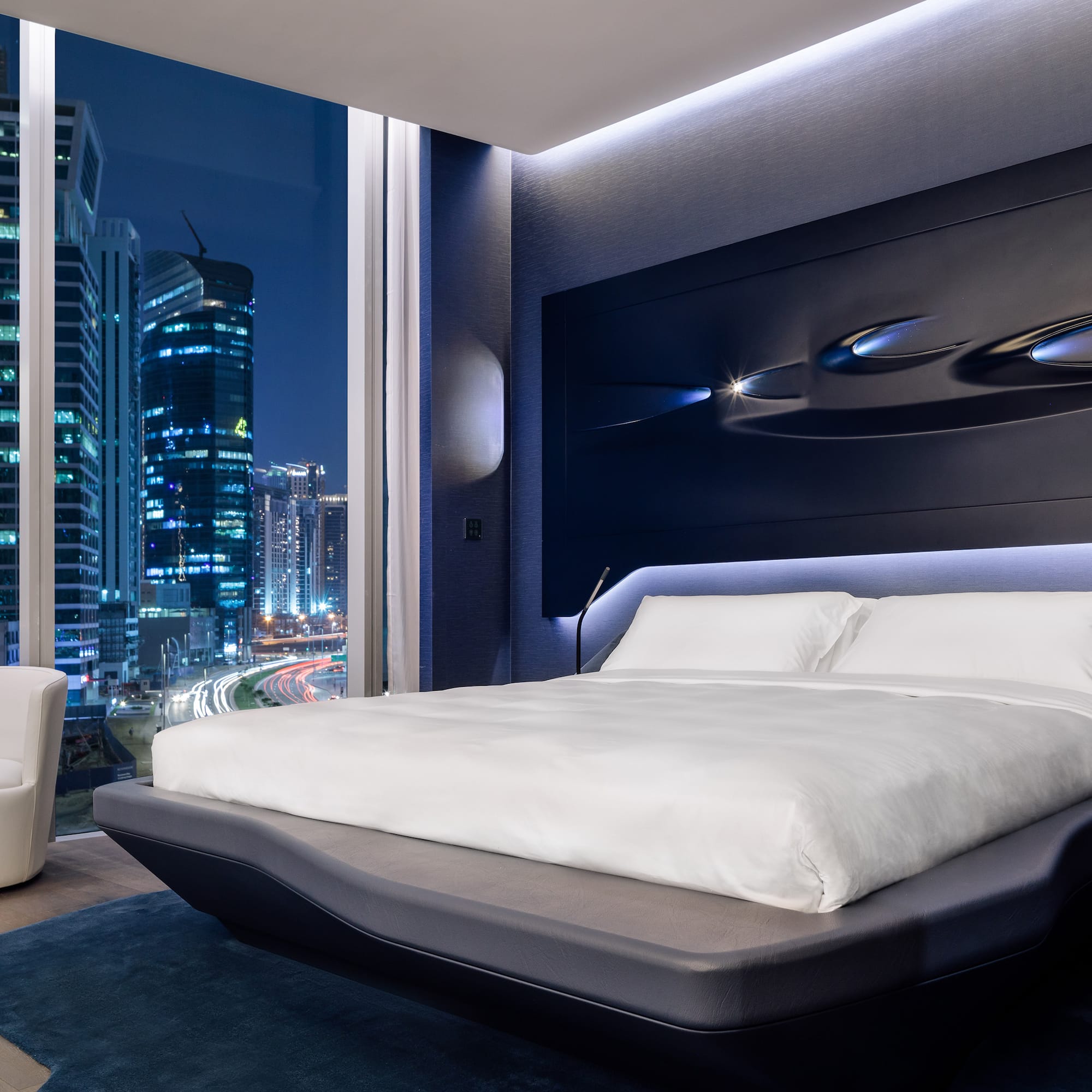 a bedroom with a large window and a large bed