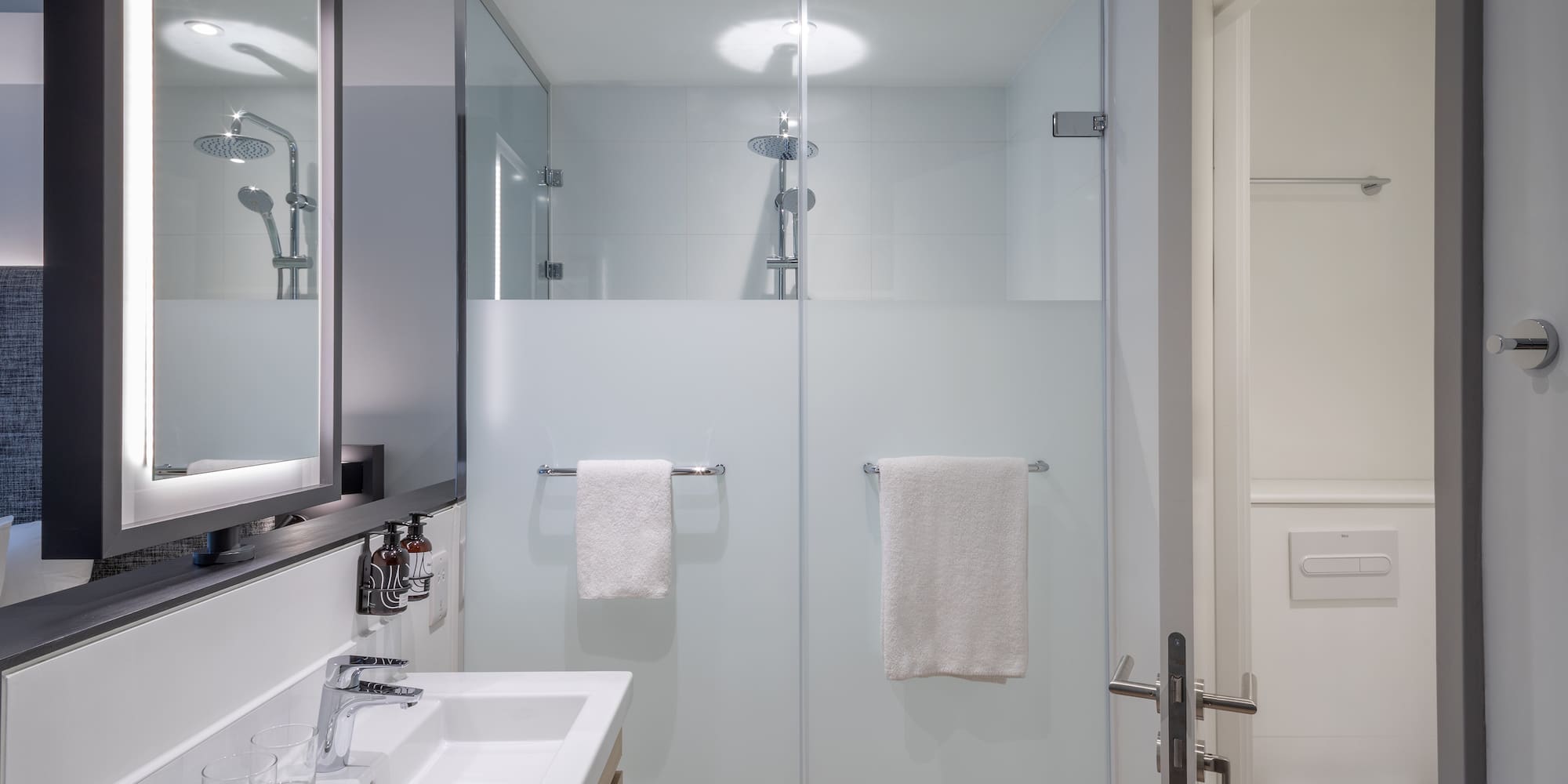 a bathroom with a glass shower door and sink