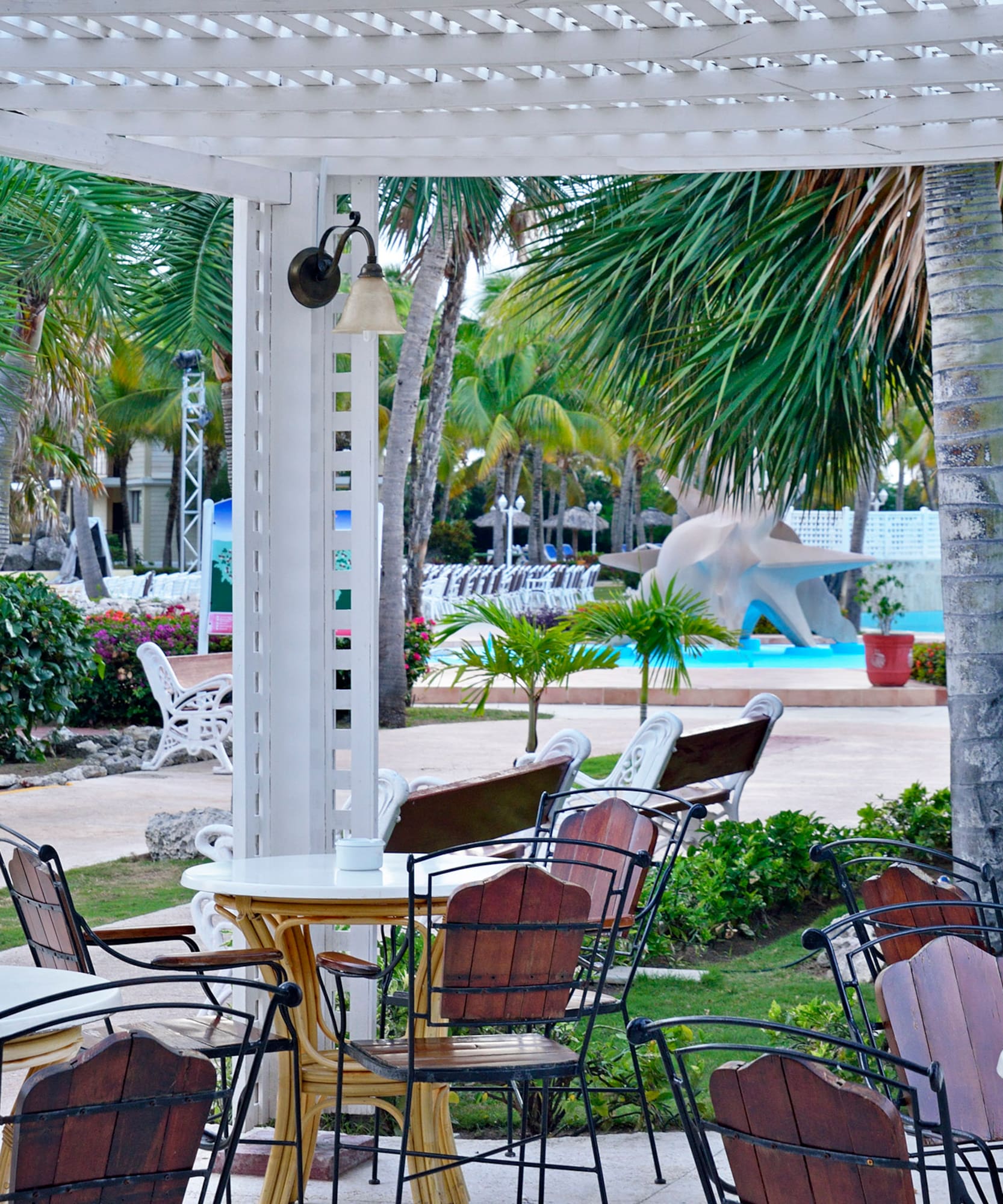 a white pergola with tables and chairs in a resort
