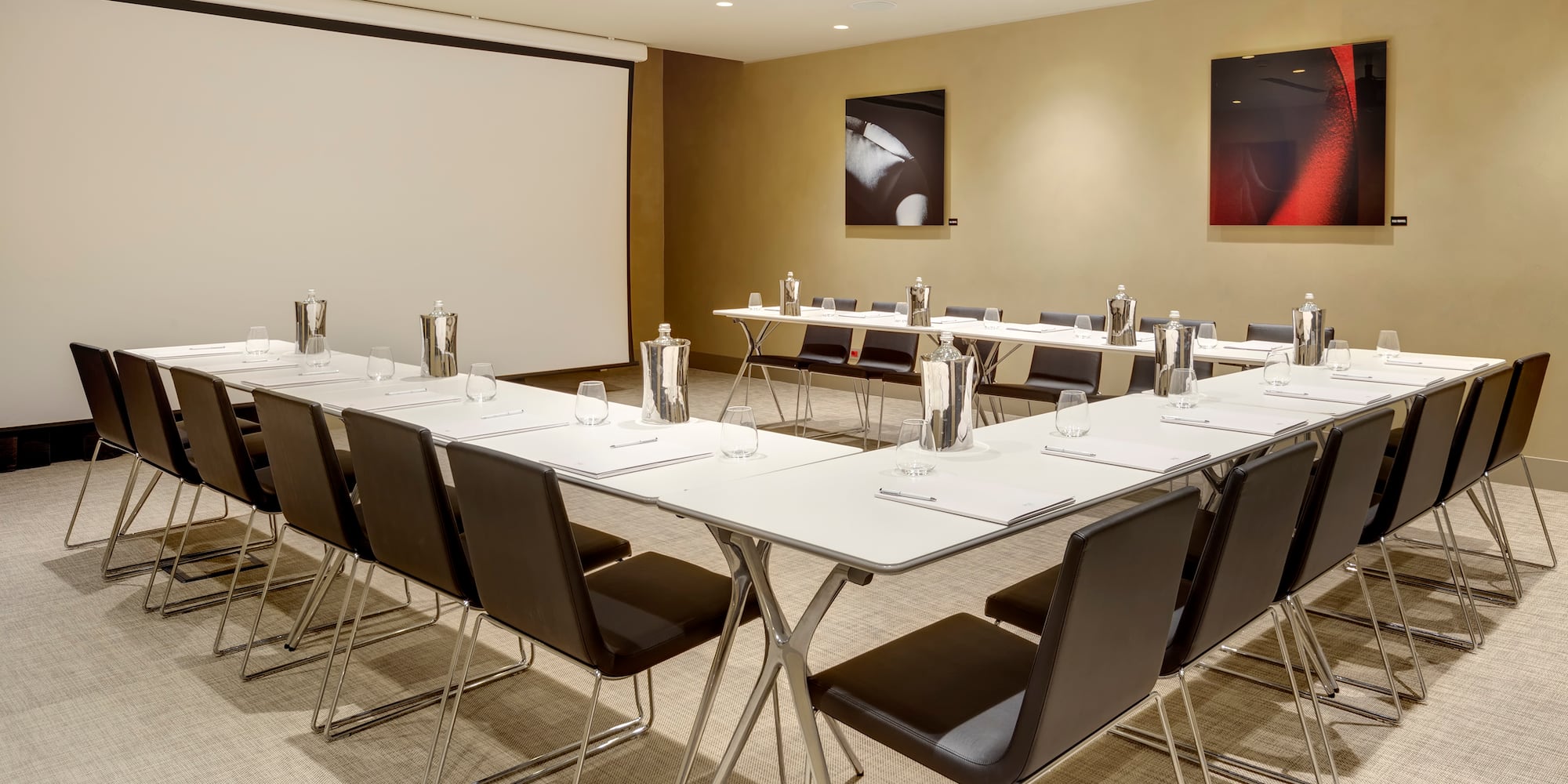 a room with a projection screen and tables