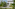 Modern white building with concrete stairs, lush tropical garden, and outdoor path.
