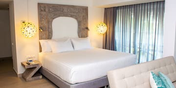 a bed with a headboard and lamps in a room