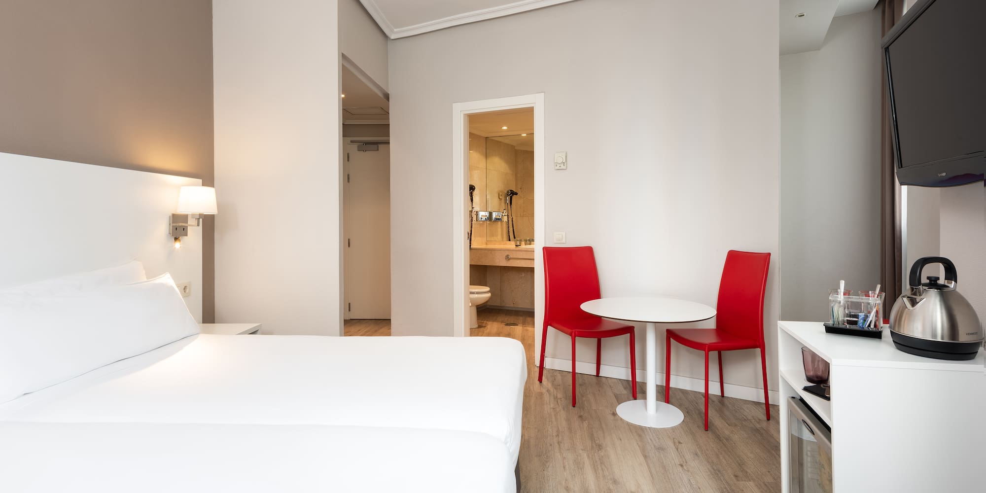 a room with a bed and a table and chairs