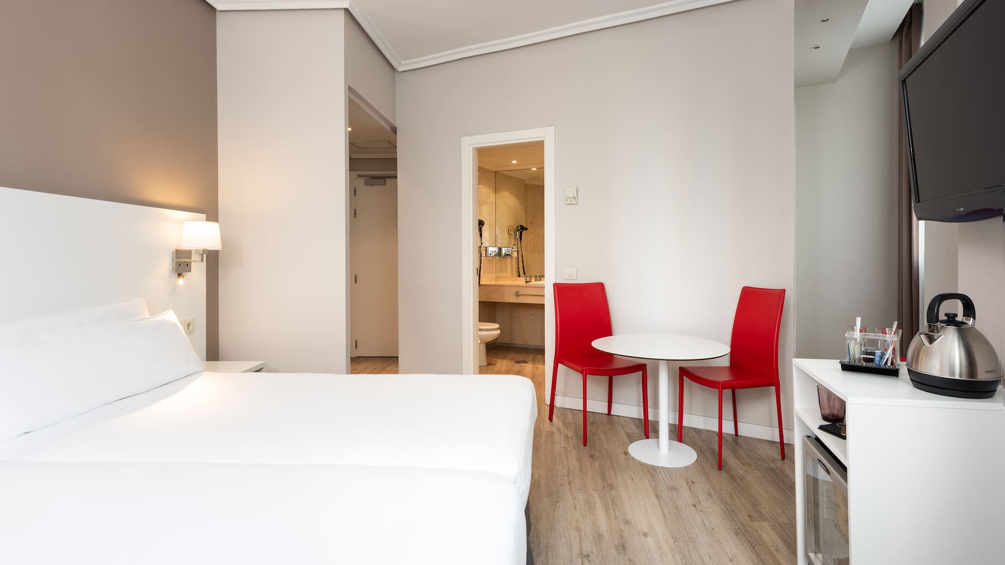 a room with a bed and a table and chairs