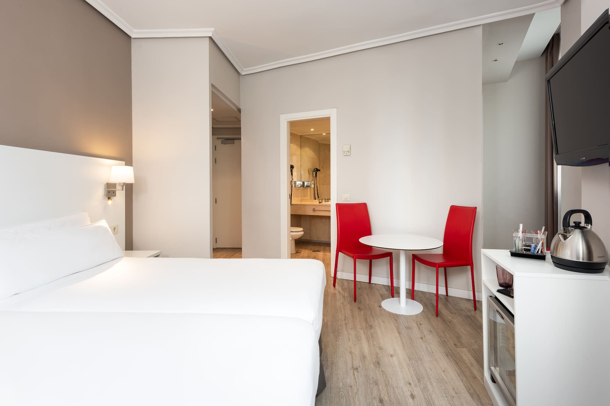 a room with a bed and a table and chairs