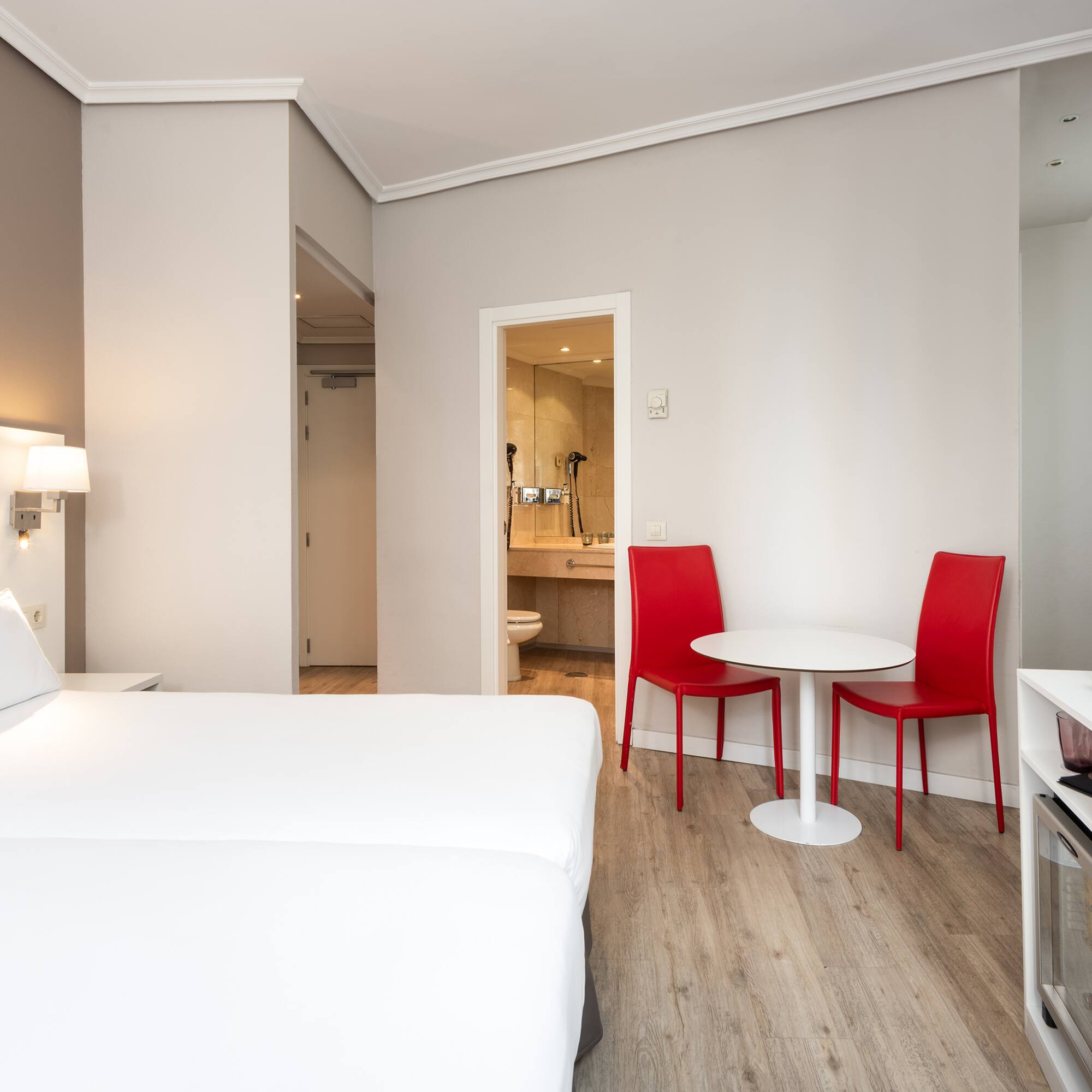 a room with a bed and a table and chairs