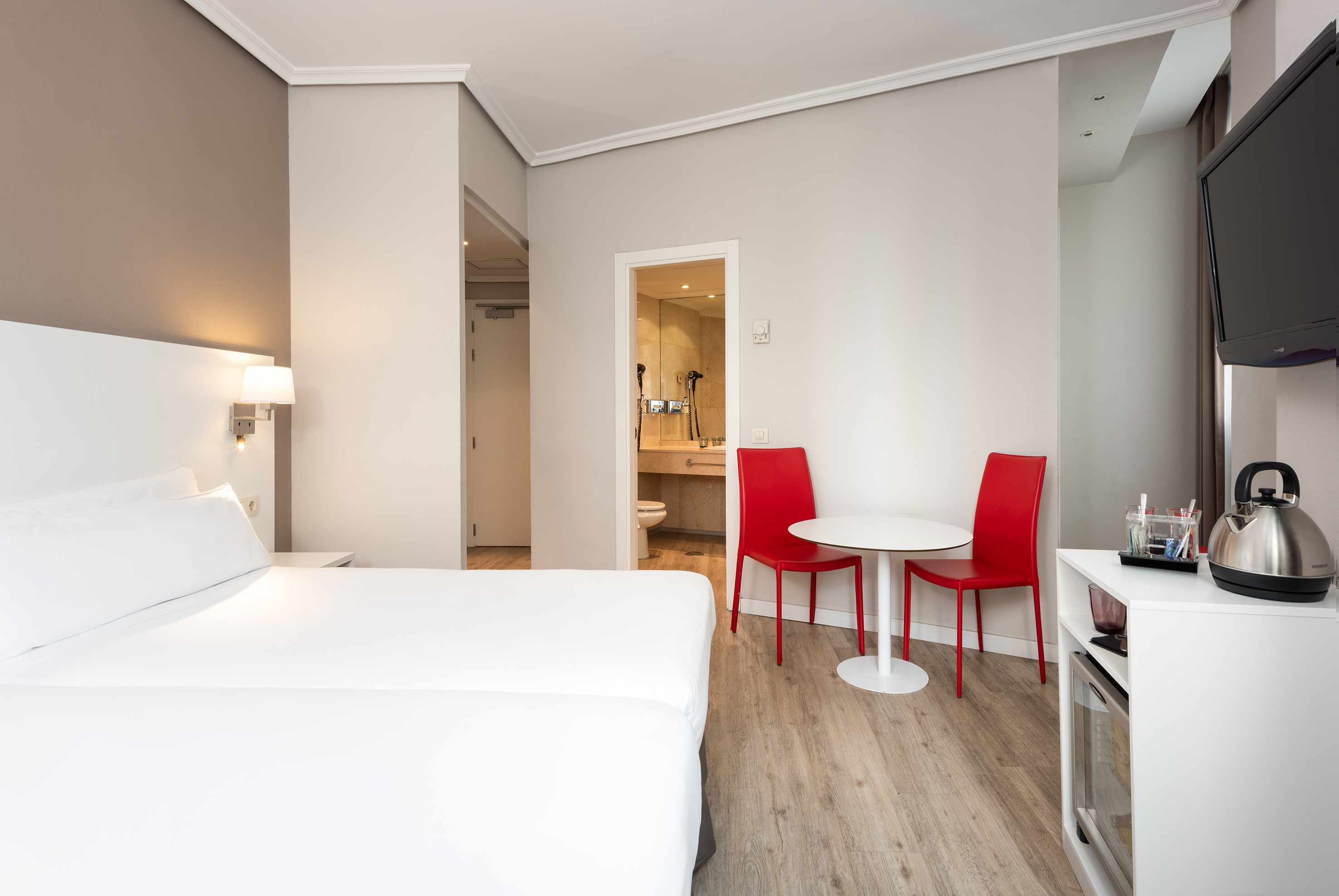 a room with a bed and a table and chairs