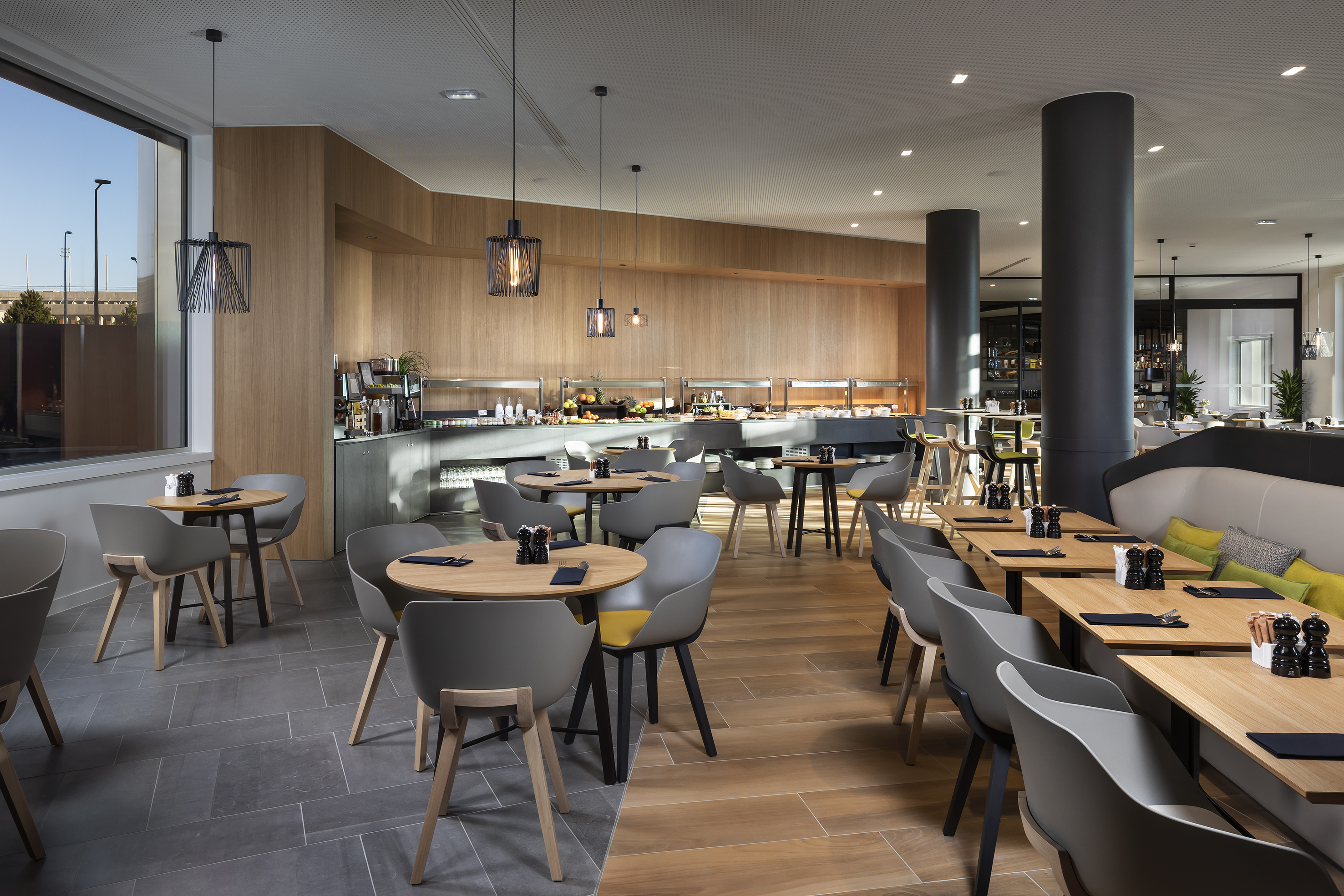 Stylish restaurant interior with buffet line, varied seating, and wood accents.