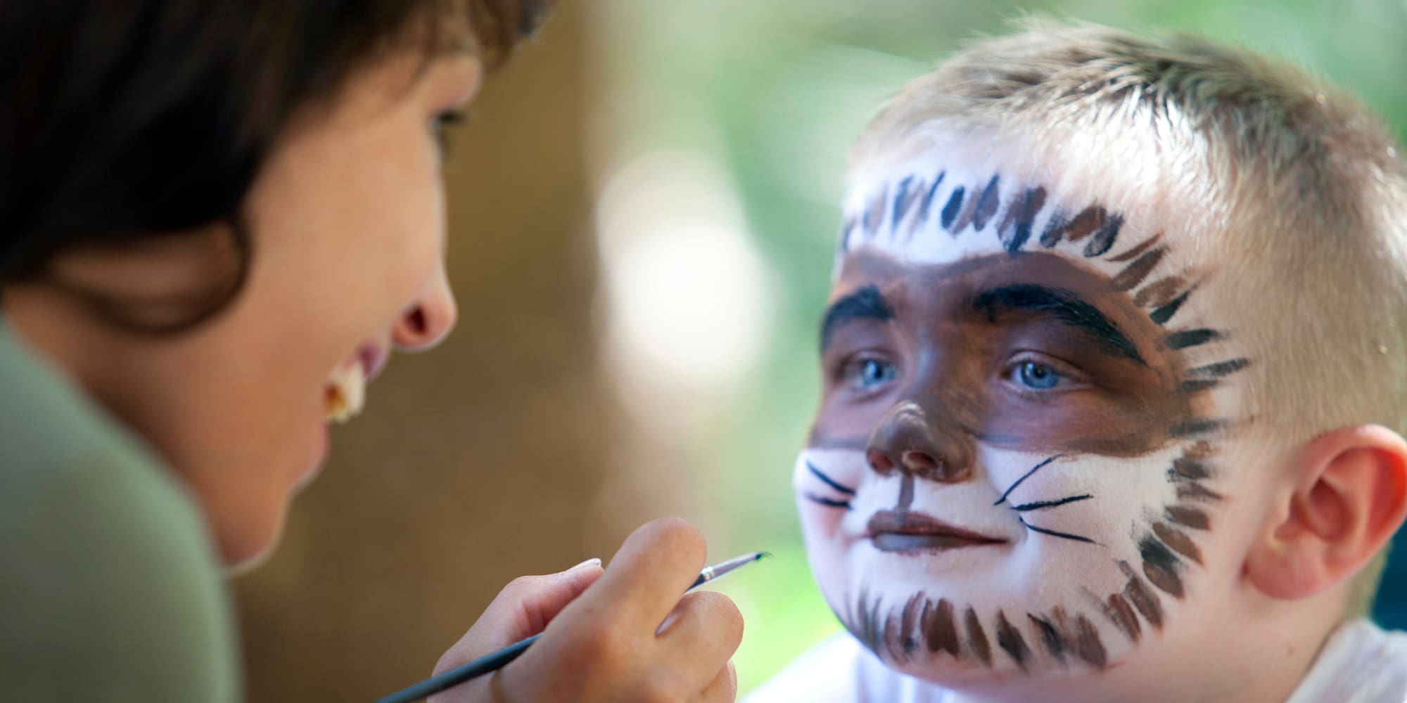 a woman painting a child's face