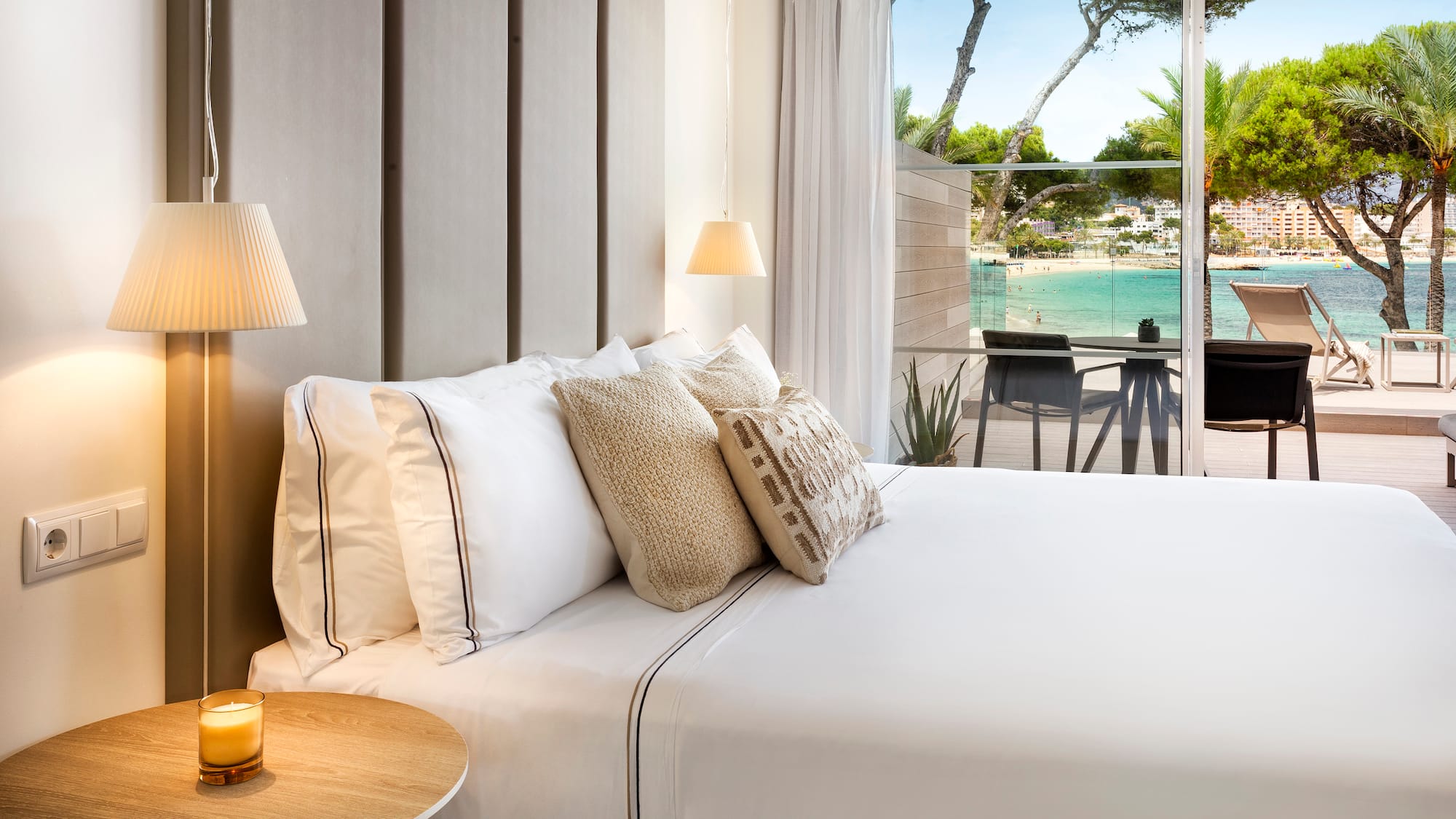 a bed with pillows and a table with lamps