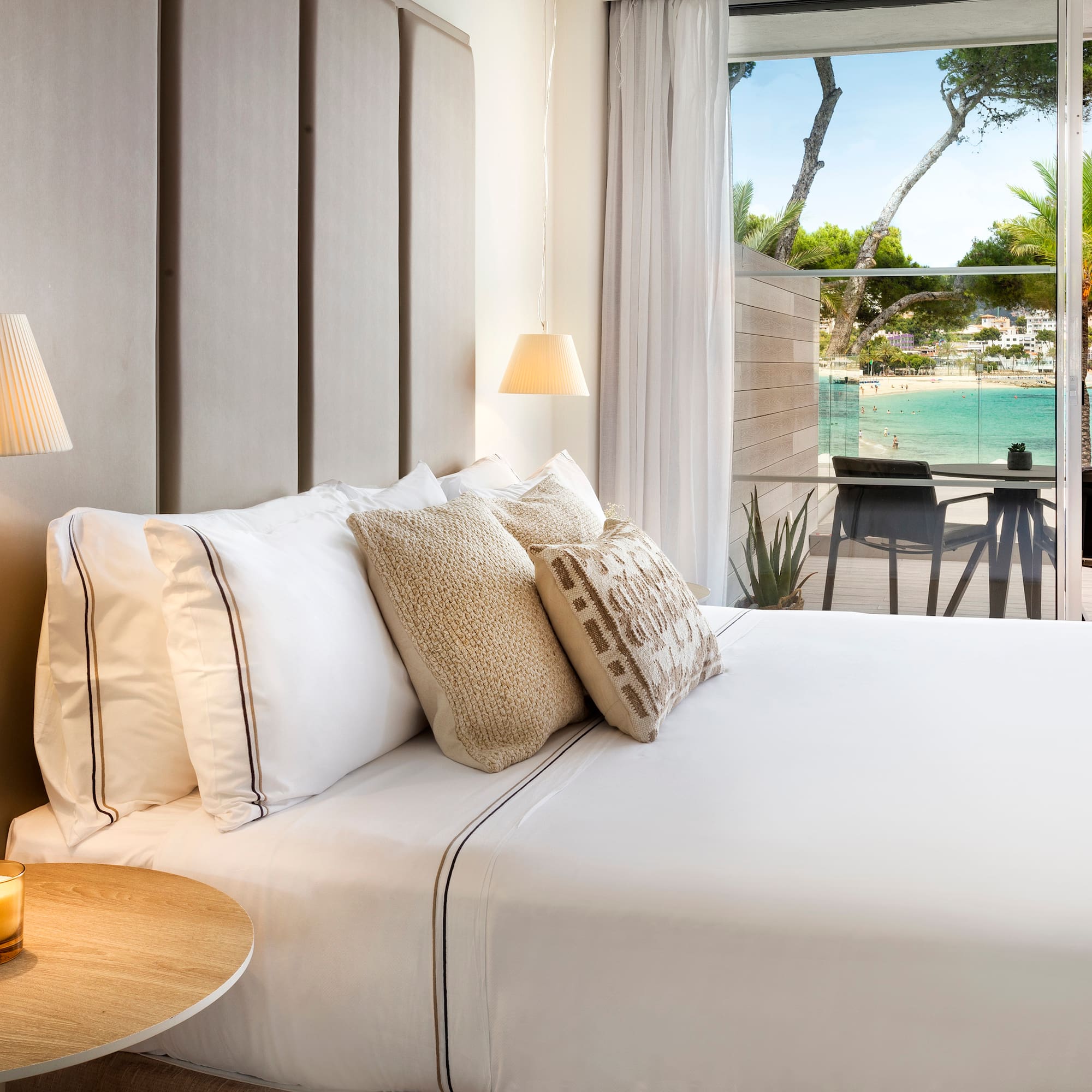 a bed with pillows and a table with lamps