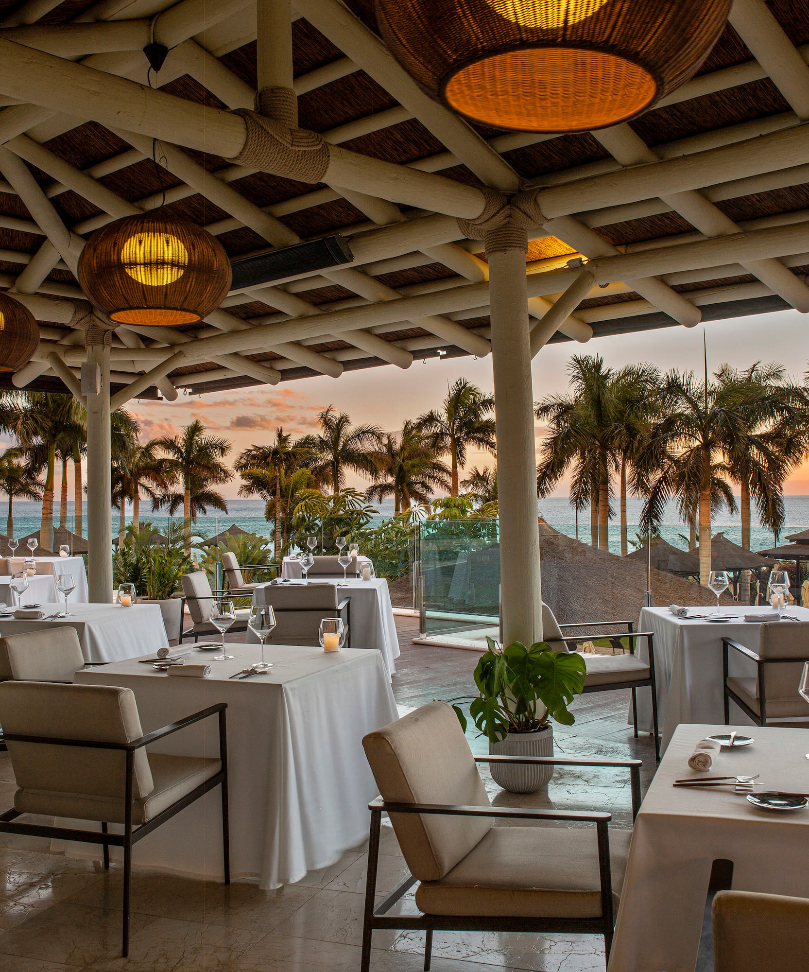 a restaurant with tables and chairs and a view of the ocean