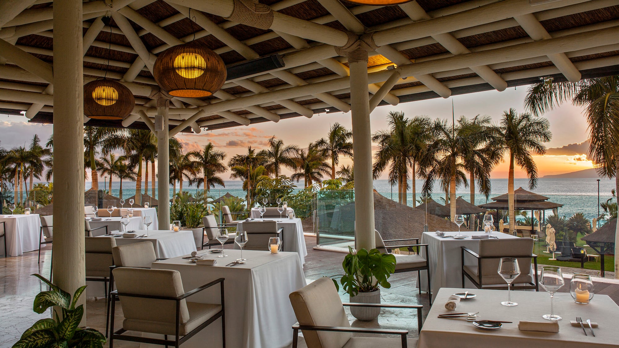 a restaurant with tables and chairs and a view of the ocean