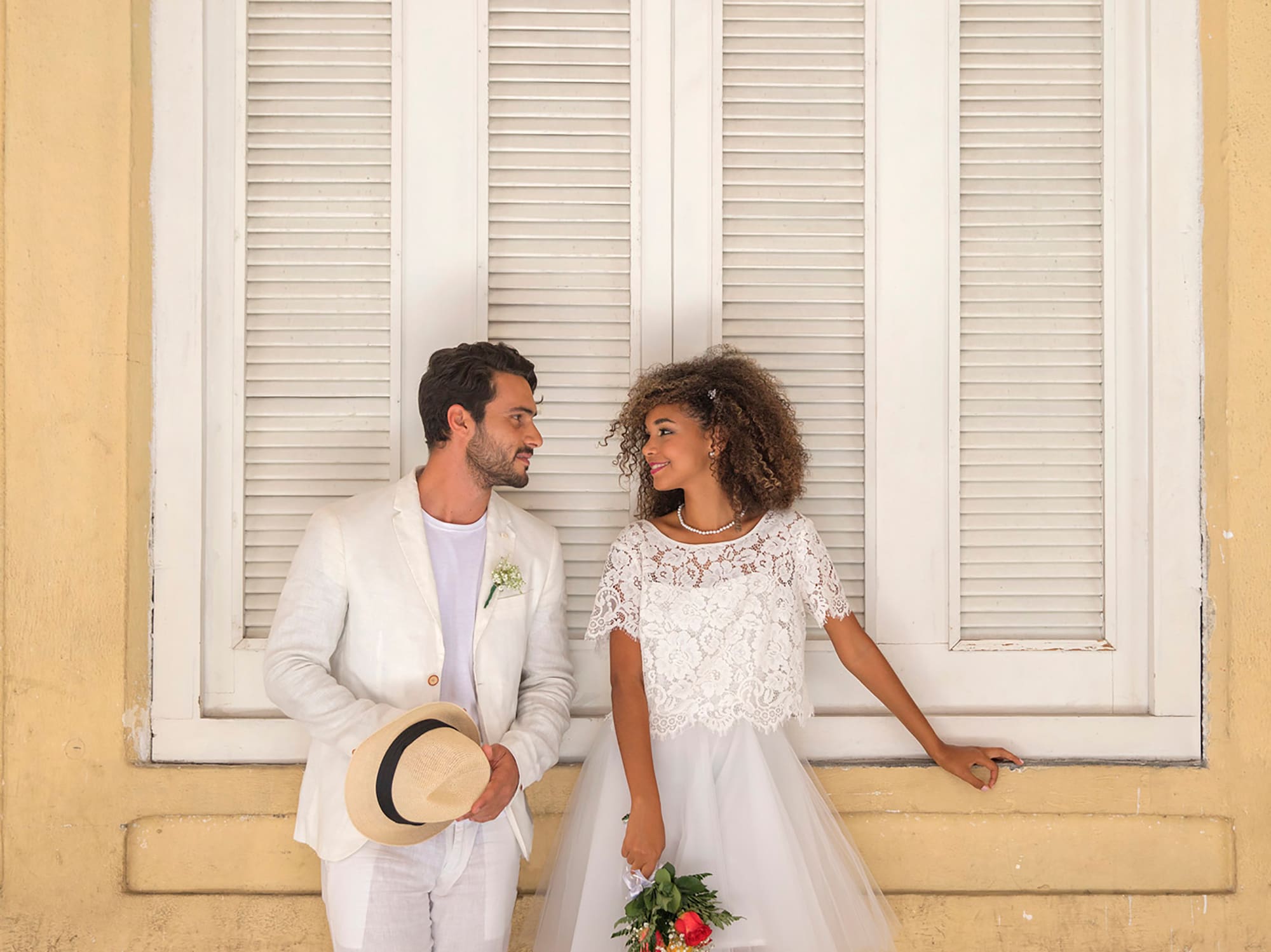 a man and woman standing in front of a window