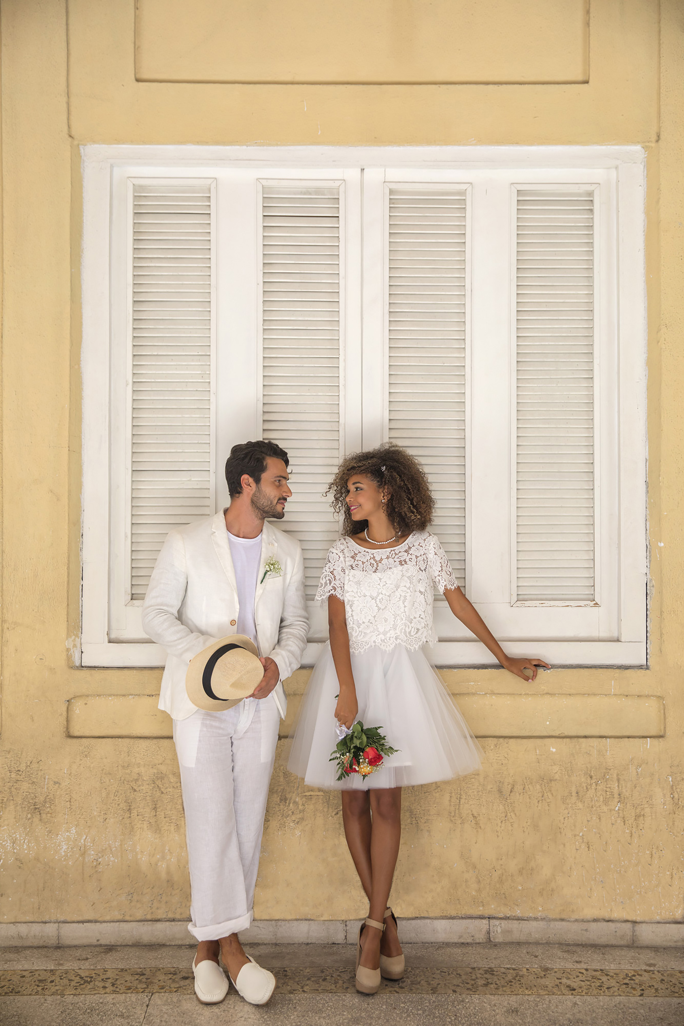 a man and woman standing in front of a window