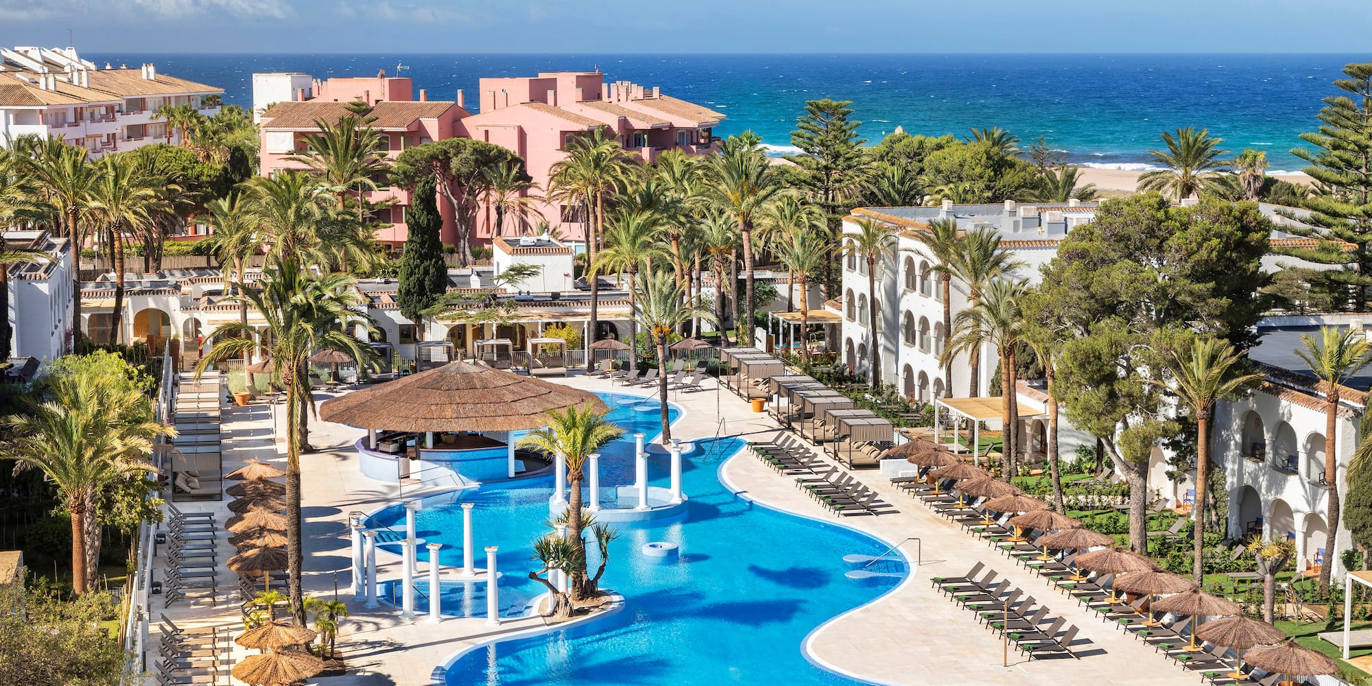 a swimming pool with palm trees and buildings