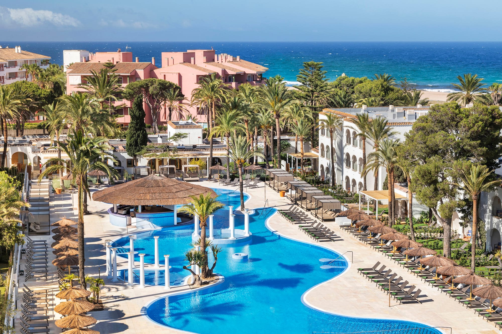 a swimming pool with palm trees and buildings