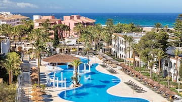 a swimming pool with palm trees and buildings