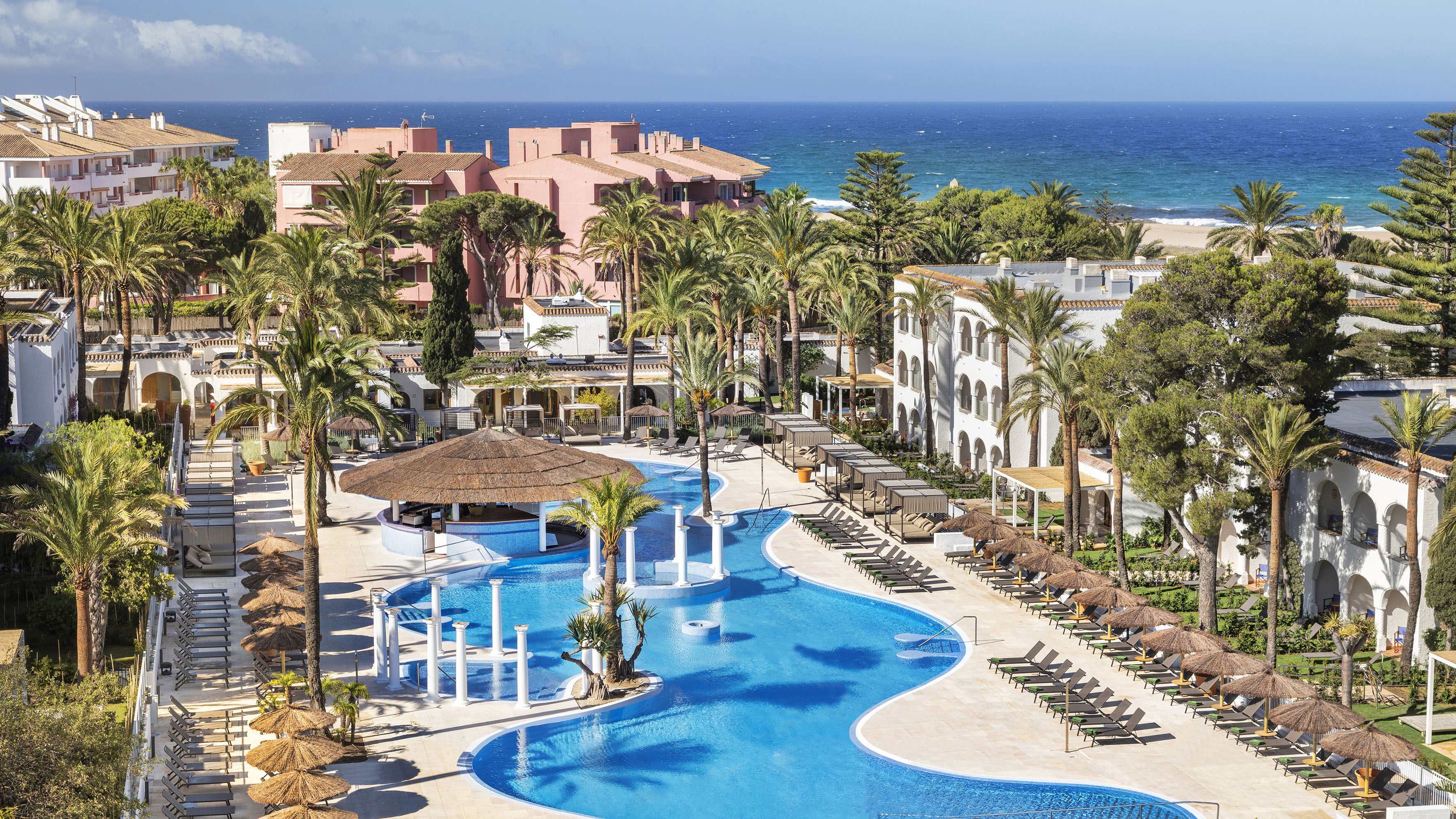 a swimming pool with palm trees and buildings