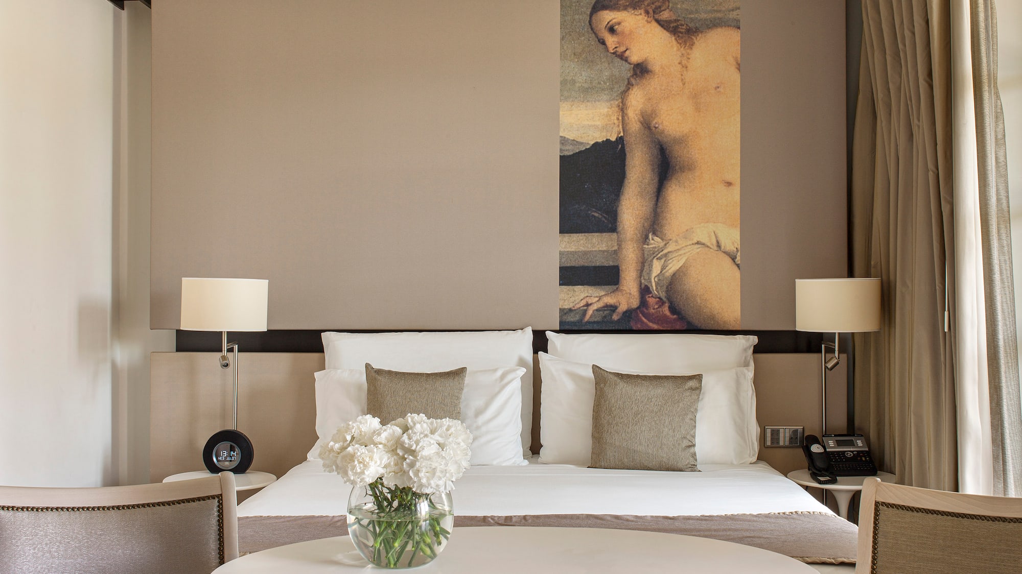 a room with a bed and chairs