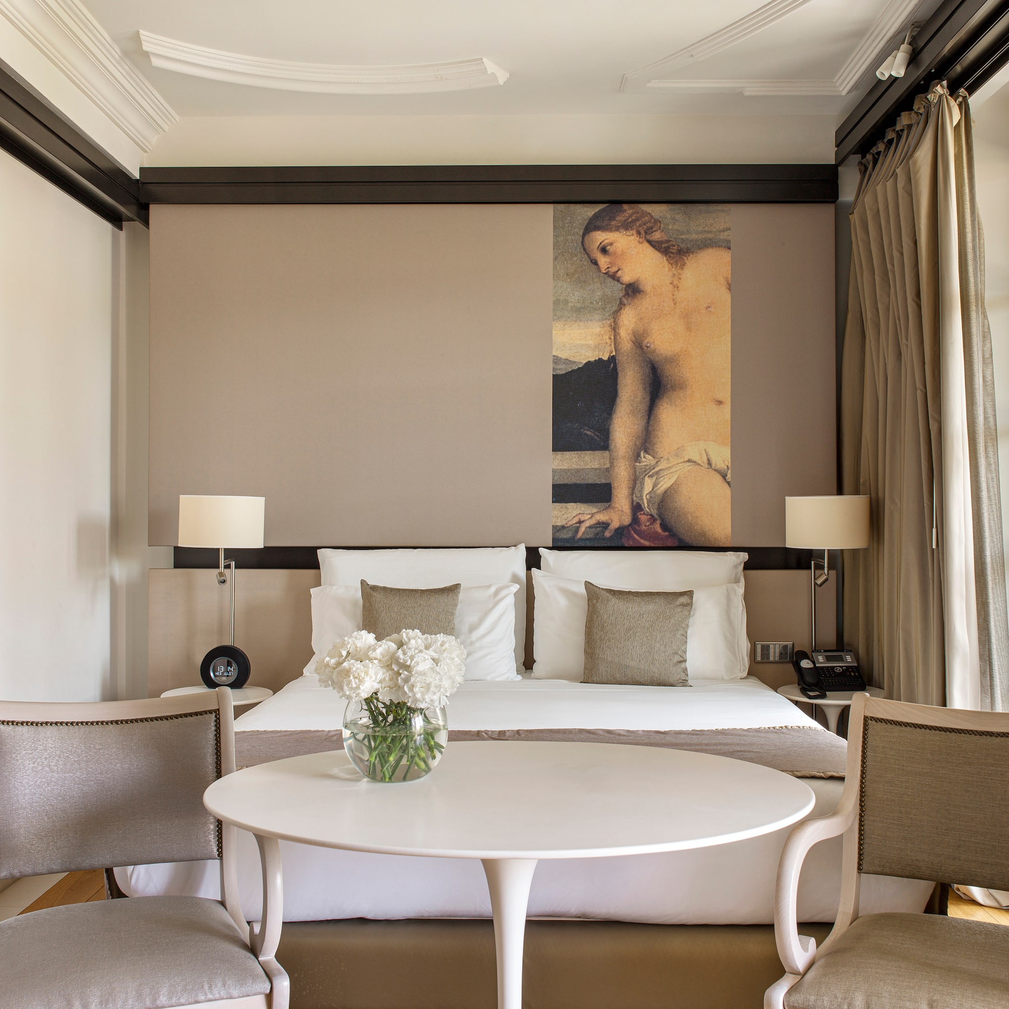 a room with a bed and chairs