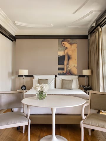 a room with a bed and chairs