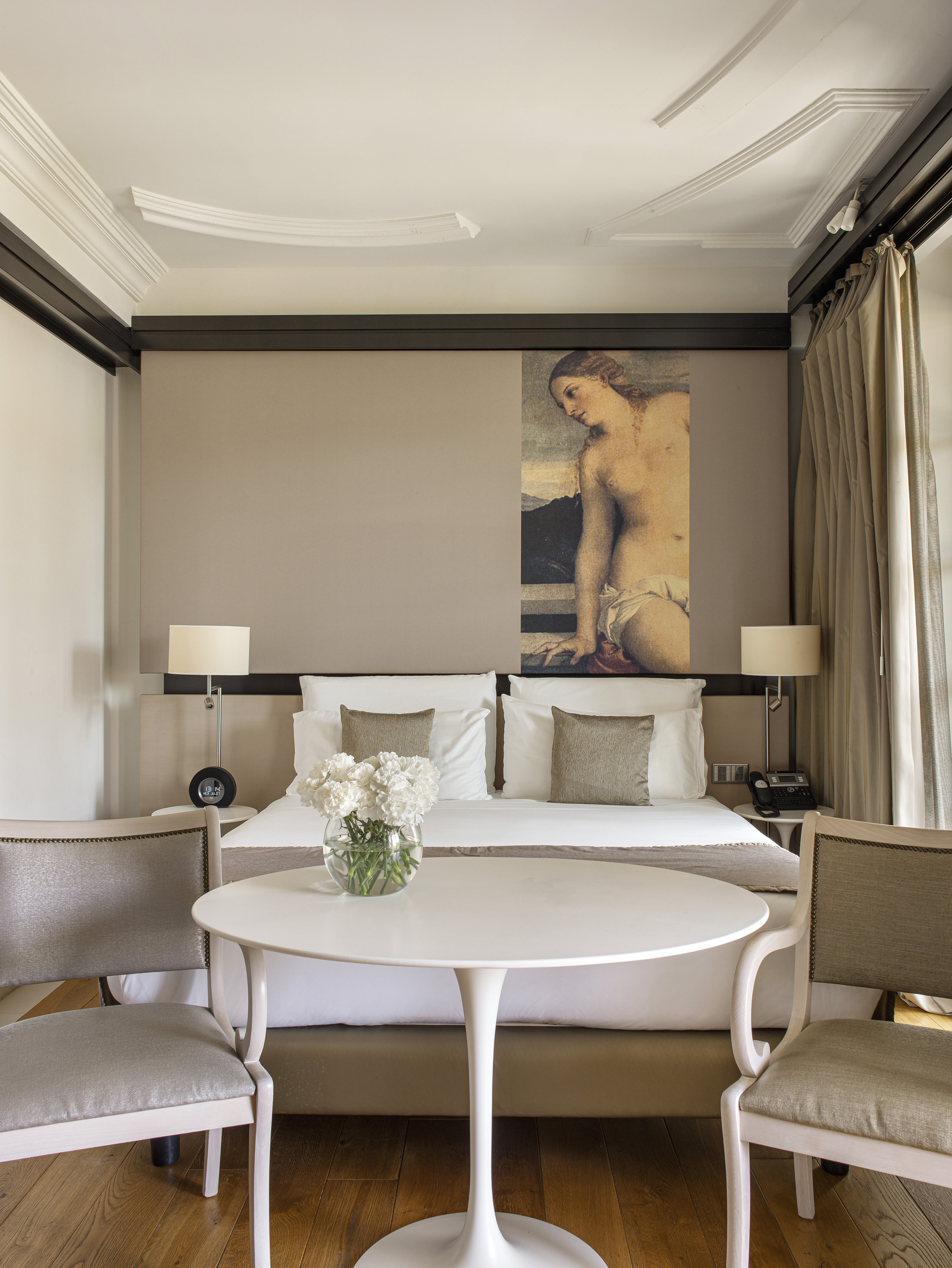 a room with a bed and chairs