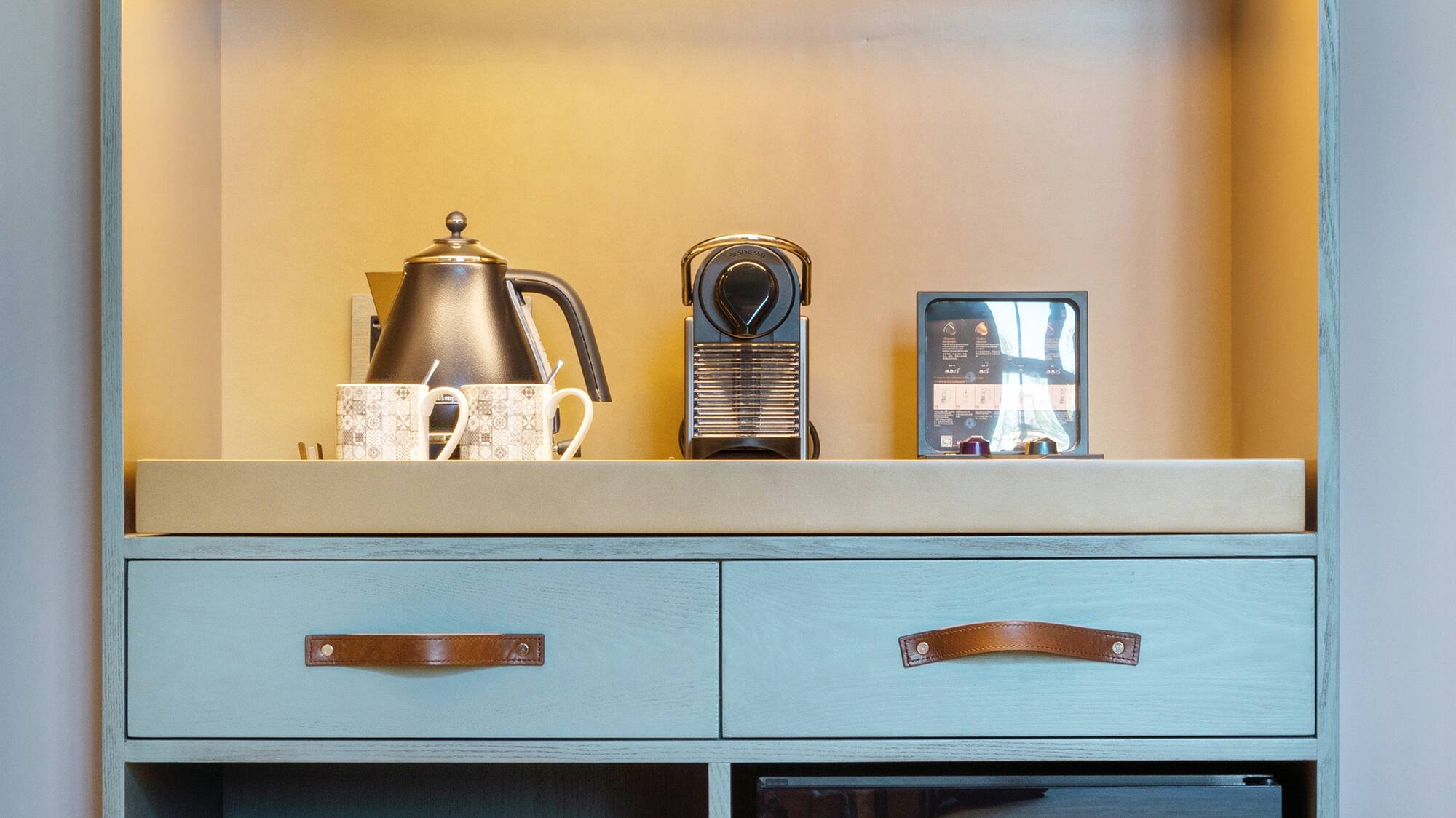 a shelf with a small refrigerator and a teapot on top