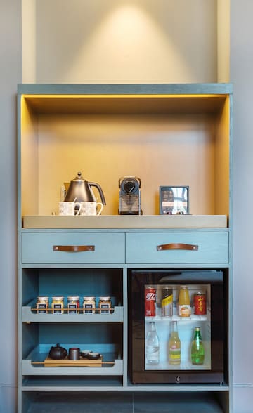 a shelf with a small refrigerator and a teapot on top