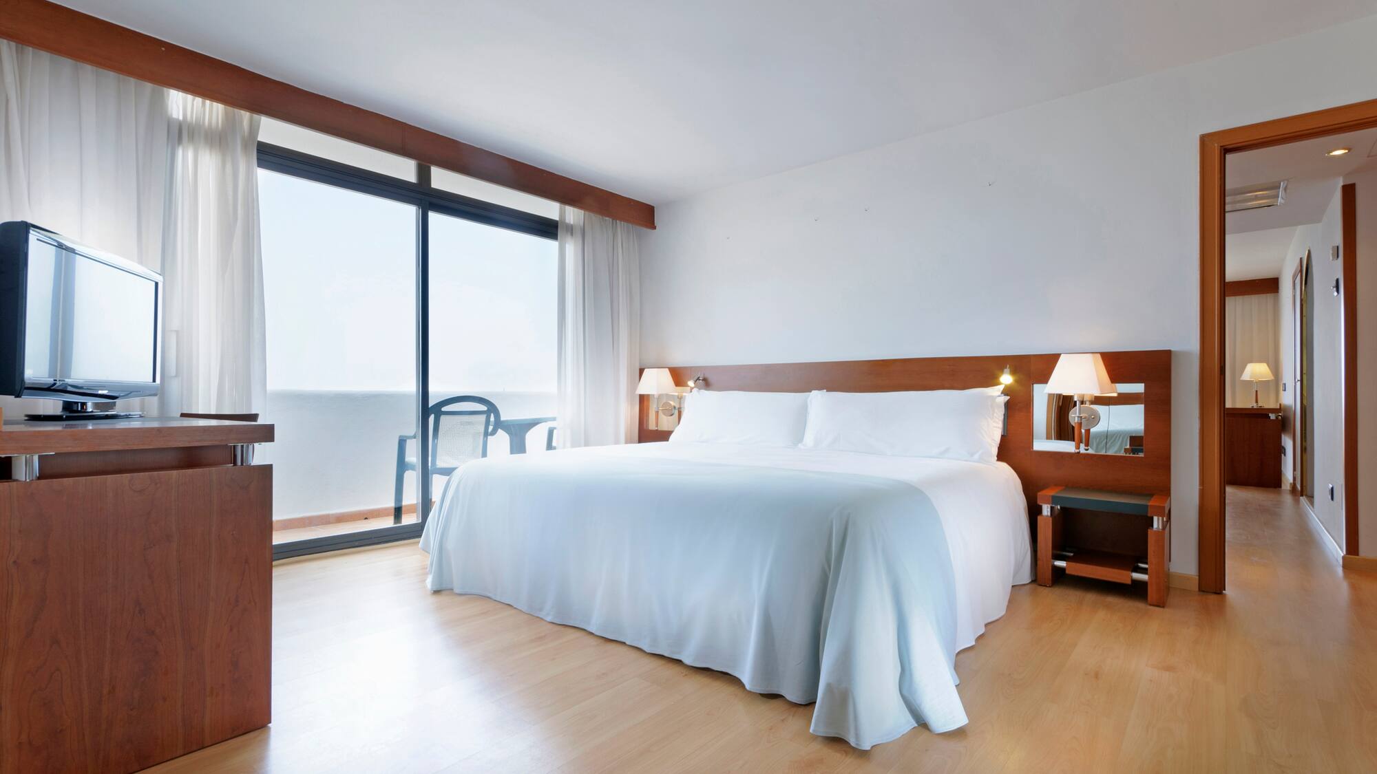 a bedroom with a large bed and a desk