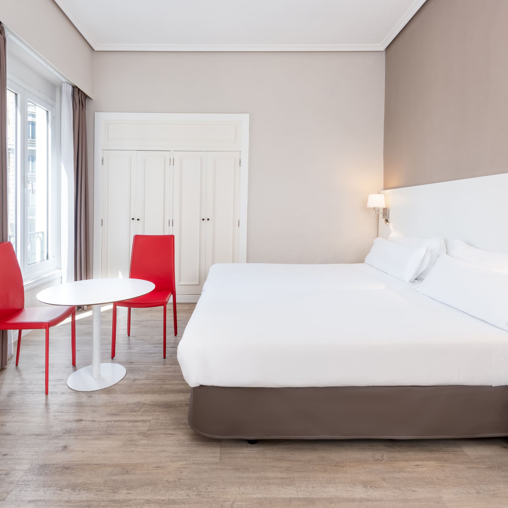 a room with a bed and chairs