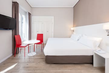 a room with a bed and chairs