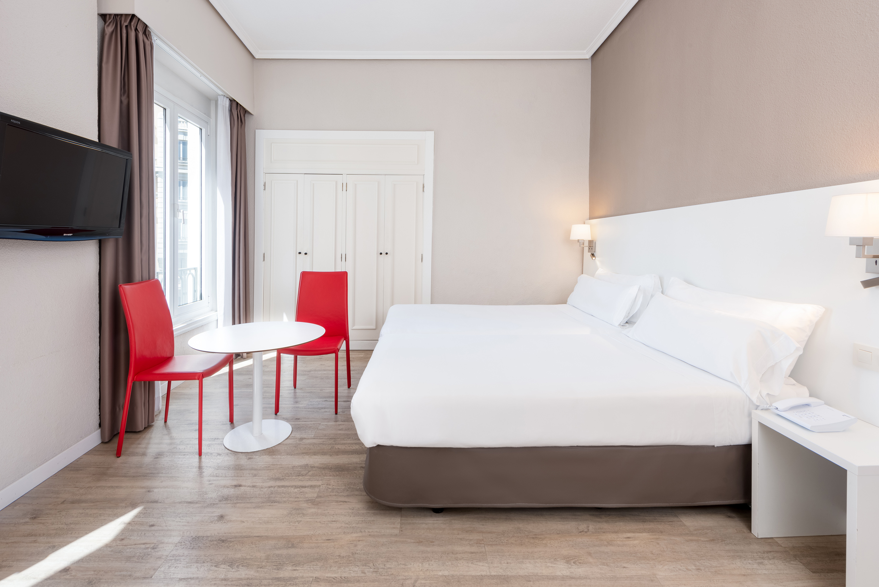 a room with a bed and chairs