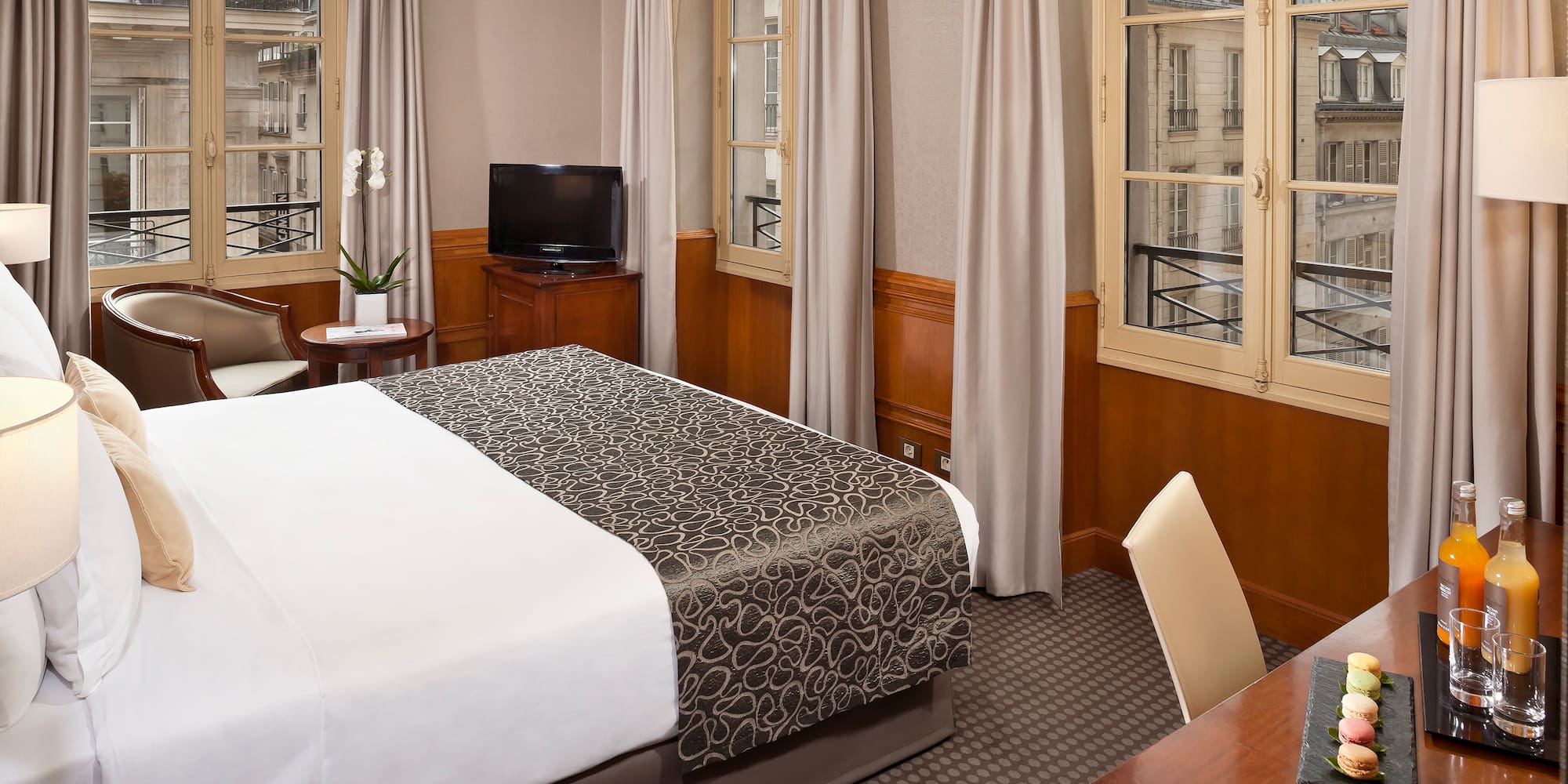 a room with a bed and a desk and a television