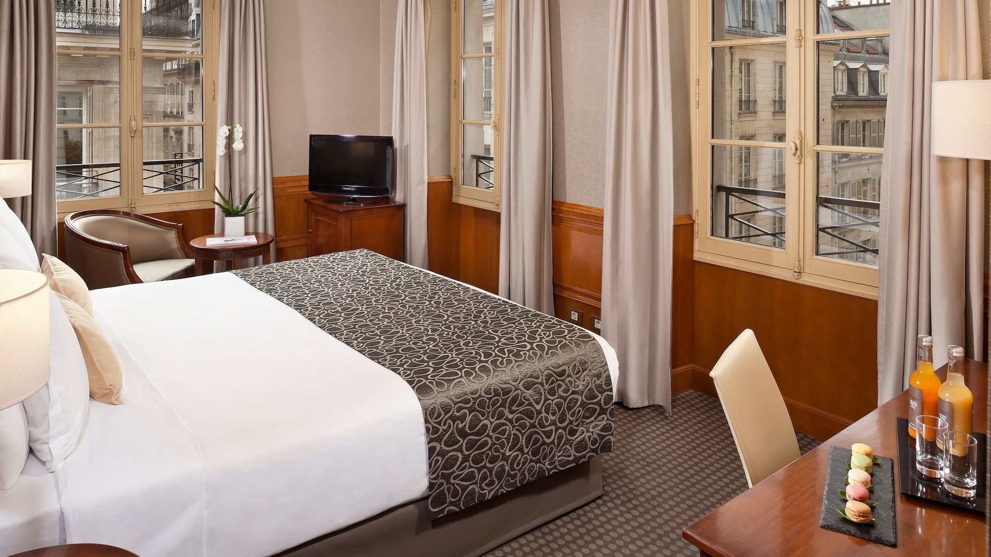 a room with a bed and a desk and a television