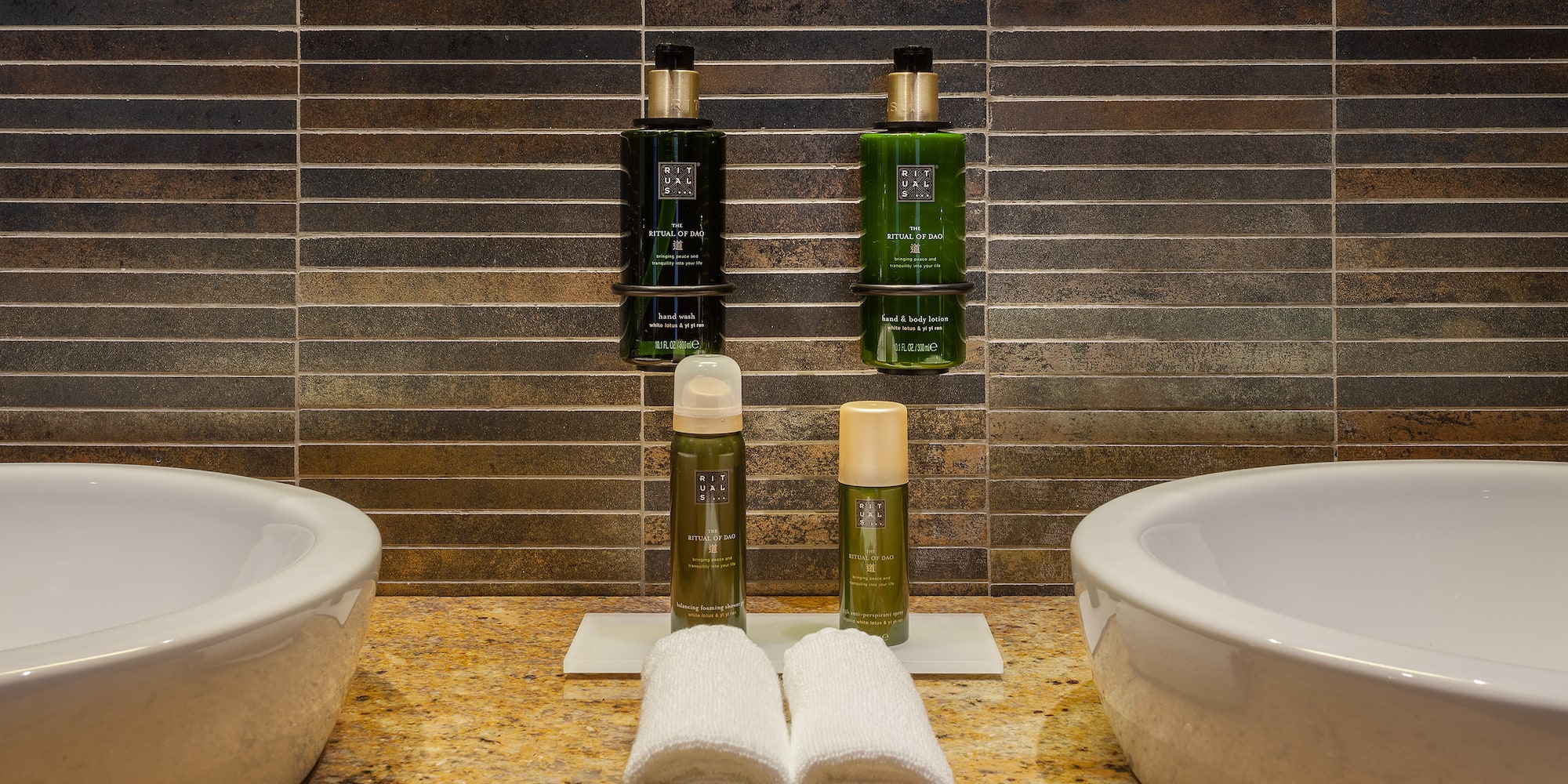 a bathroom with two sinks and two bottles of shampoo