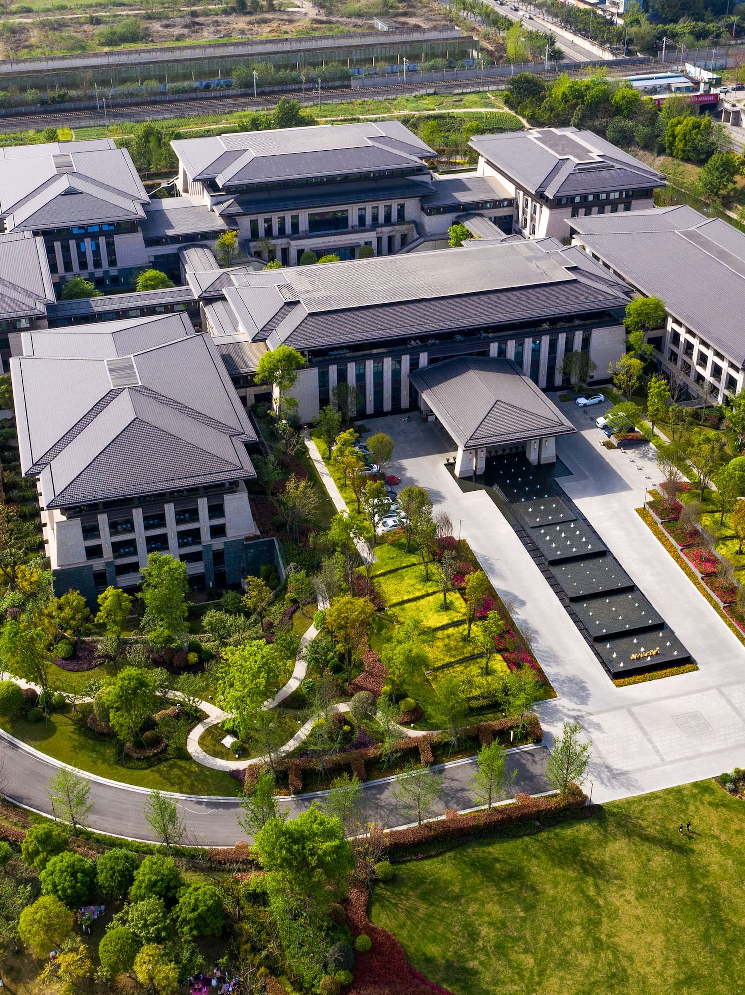 a large building with a driveway and trees