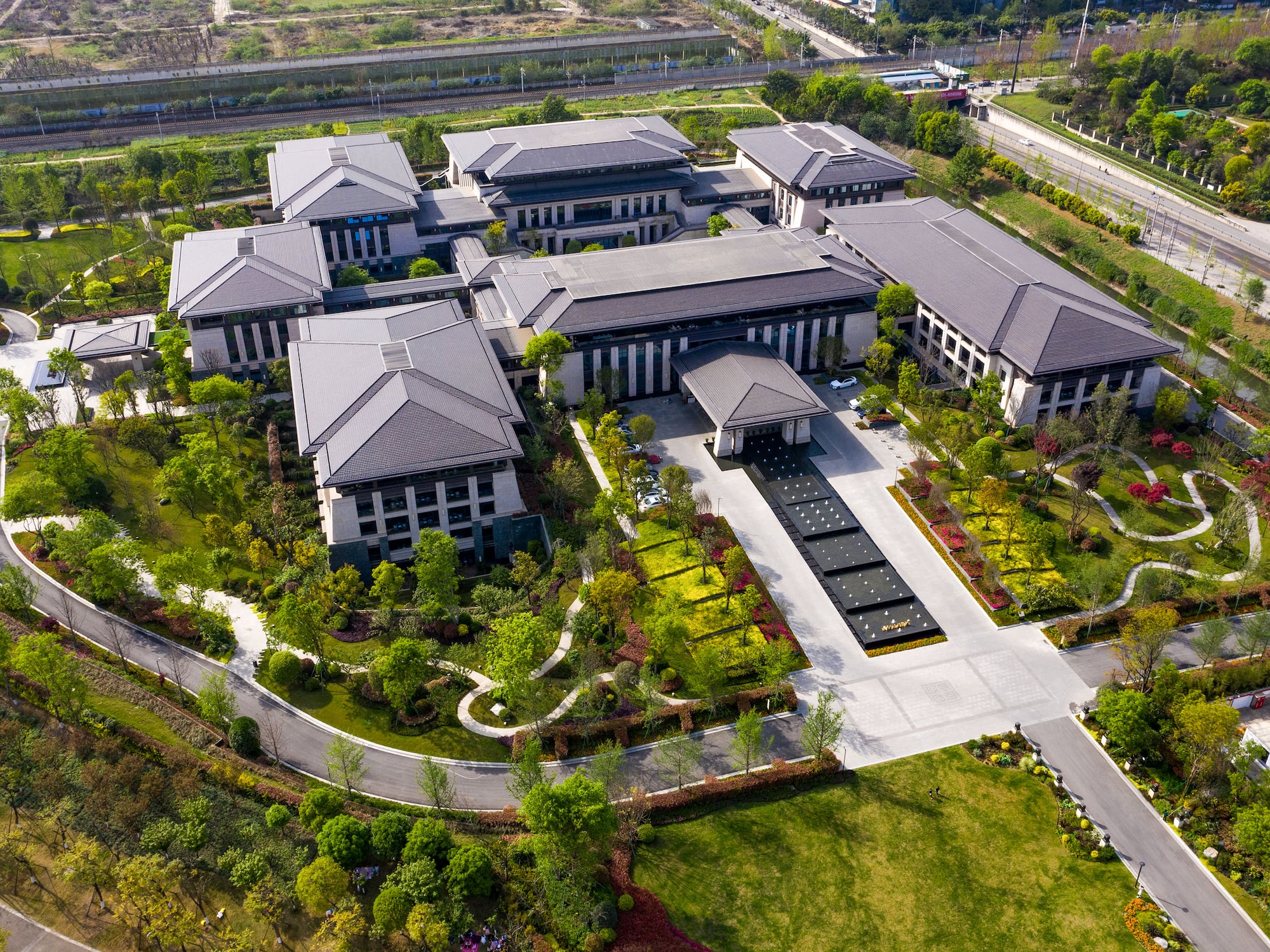a large building with a driveway and trees