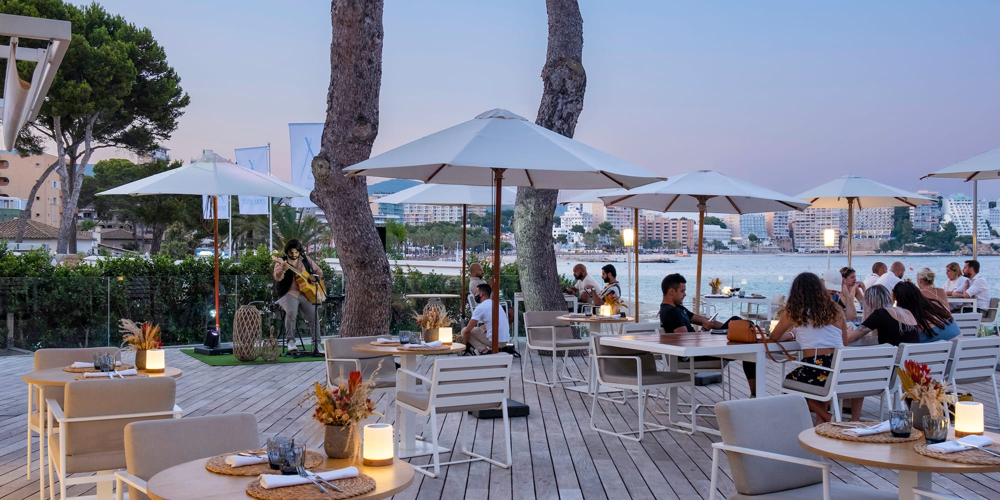 a group of people sitting at tables and chairs under umbrellas