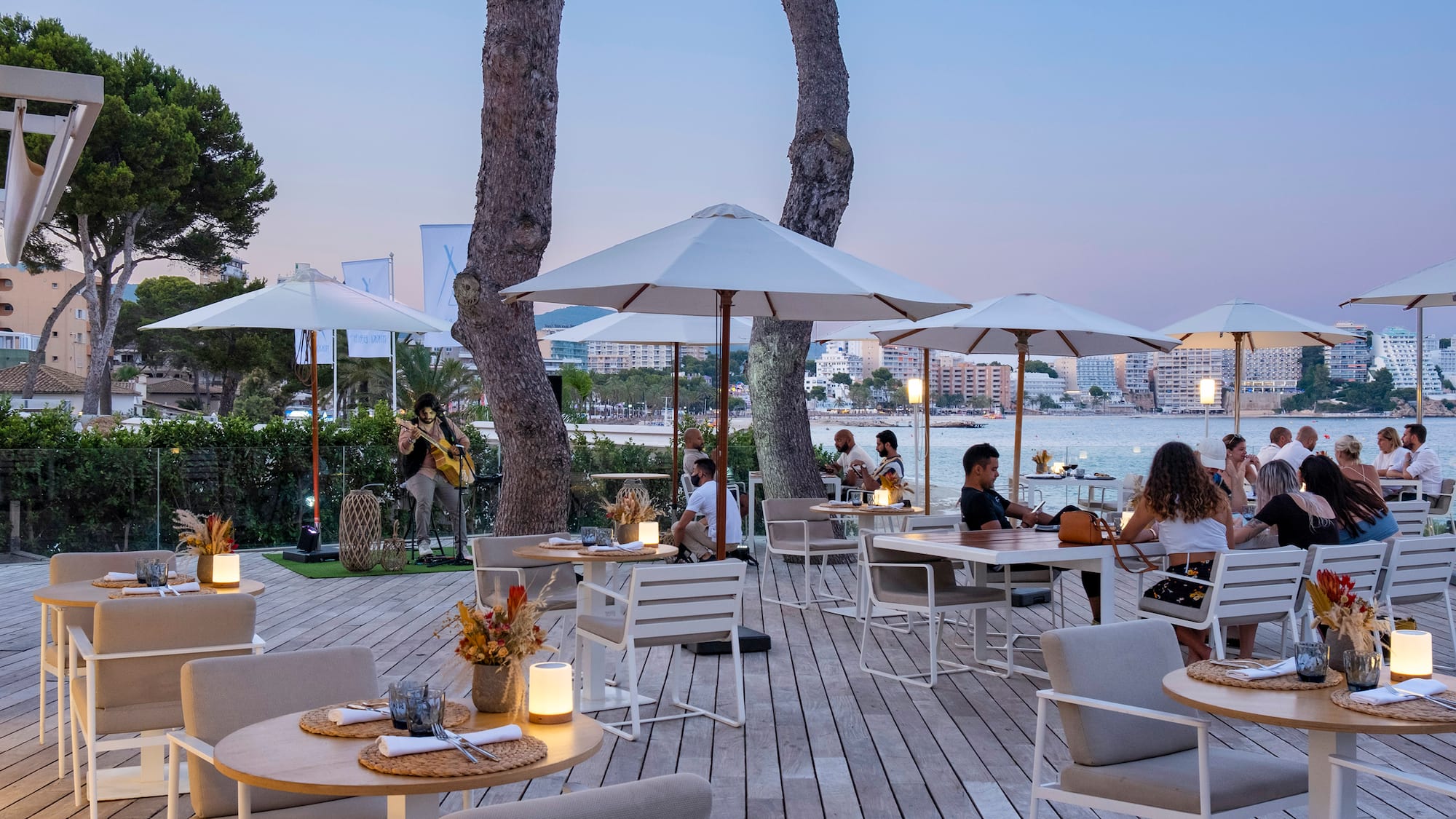 a group of people sitting at tables and chairs under umbrellas