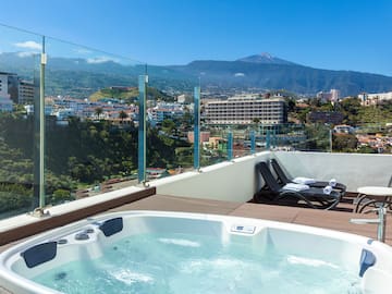 a hot tub with a view of a city and mountains