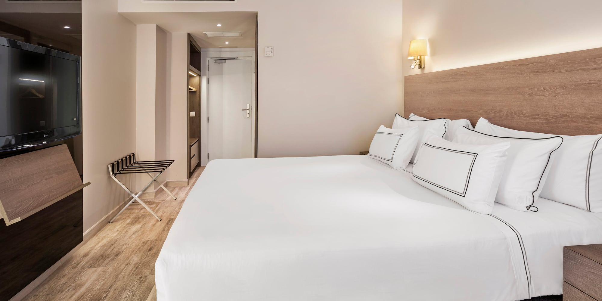 a bed with white sheets and a wood floor