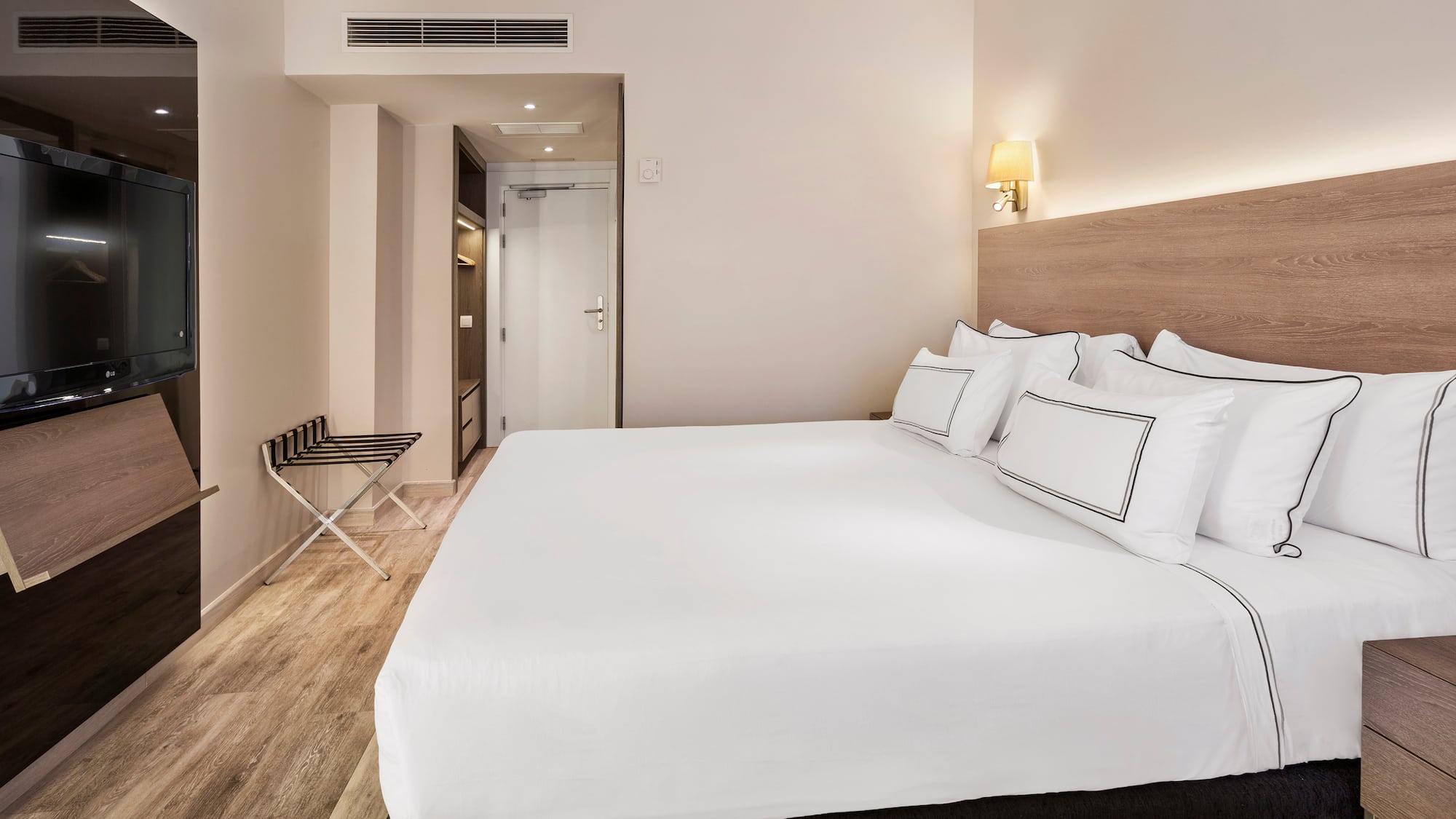 a bed with white sheets and a wood floor